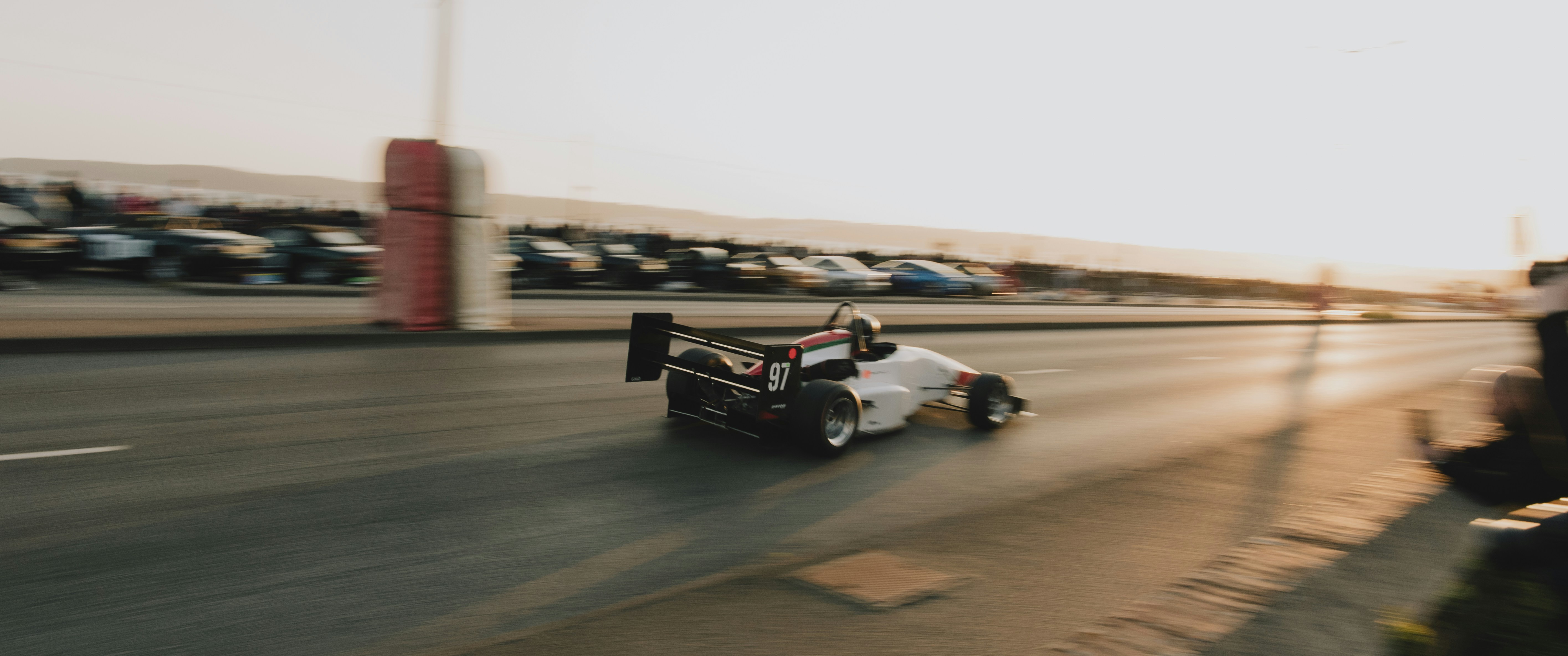 Race car speeds down the track during the day.