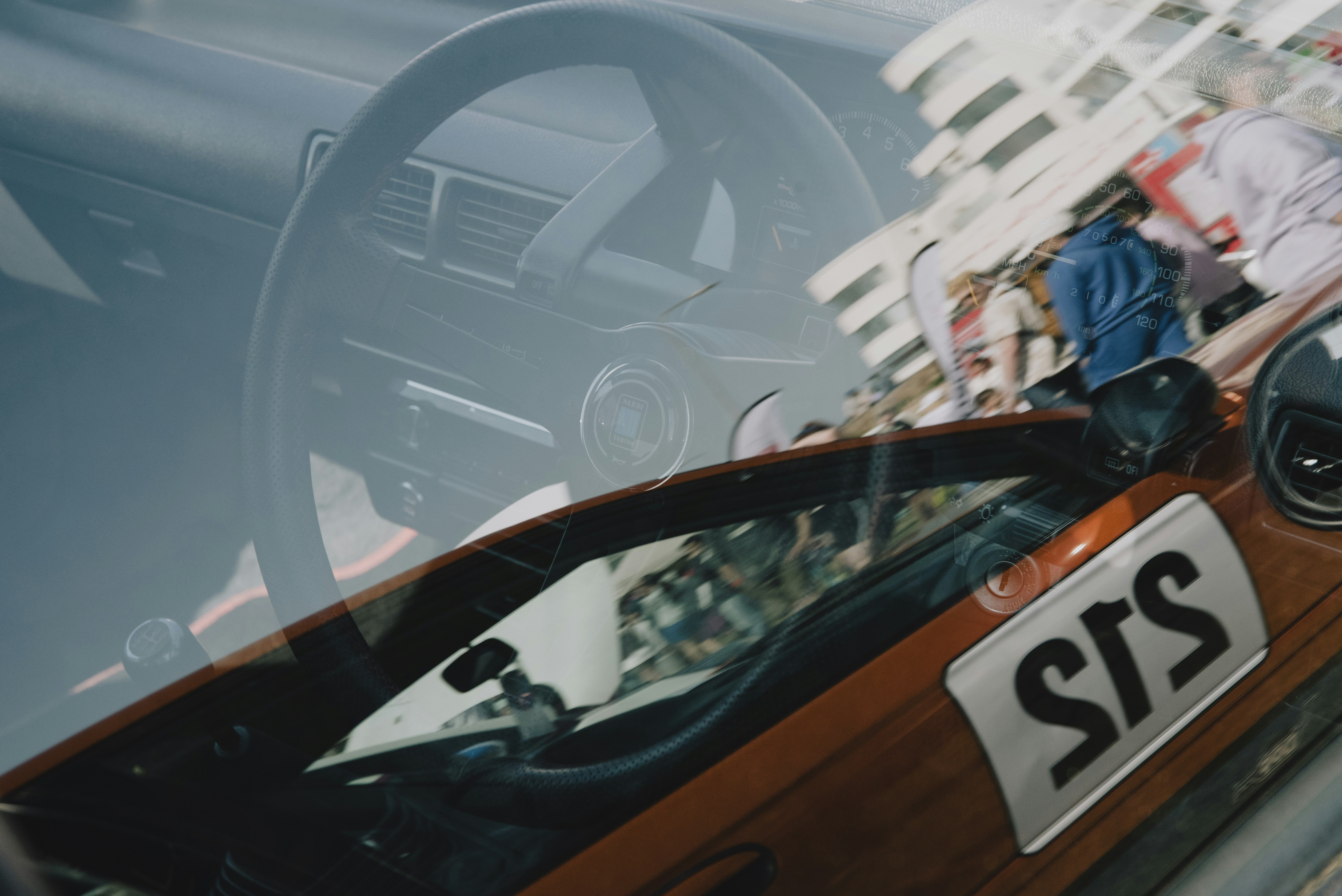 A red car with interior and people.