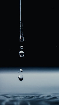 Water droplets falling on a reflective surface.