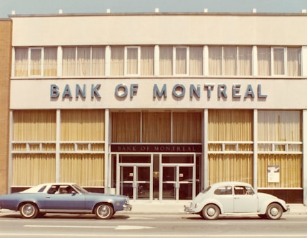 An old bank of montreal building with vintage cars.