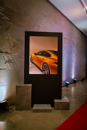 A car displayed within a frame on the wall.