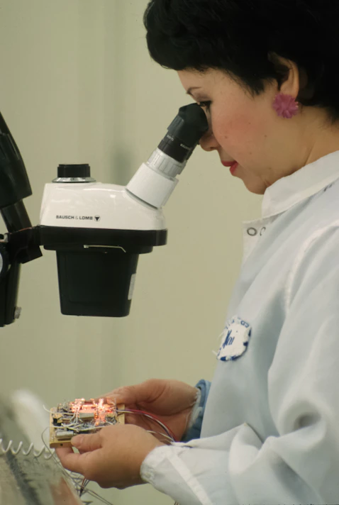 Scientist examines circuitry under a microscope