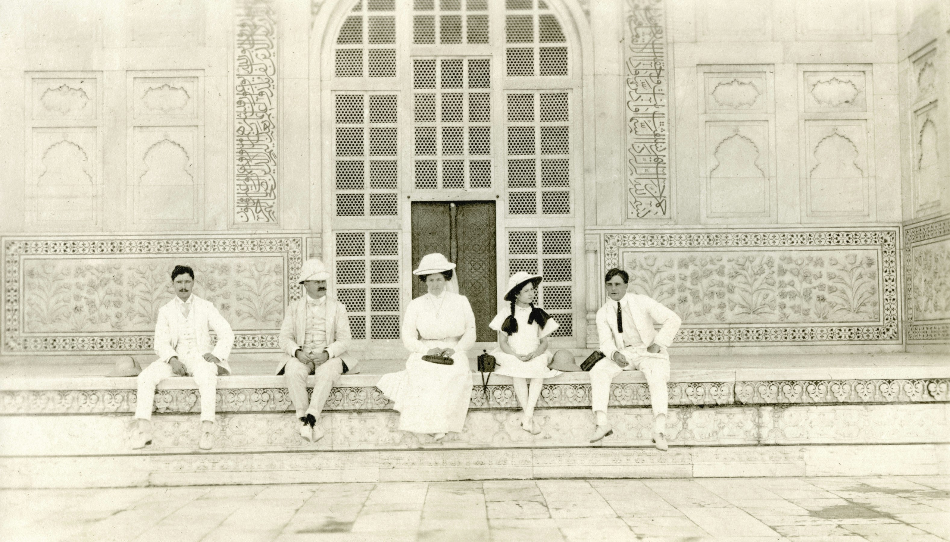 Cinque persone che posano davanti a un grande edificio ornato