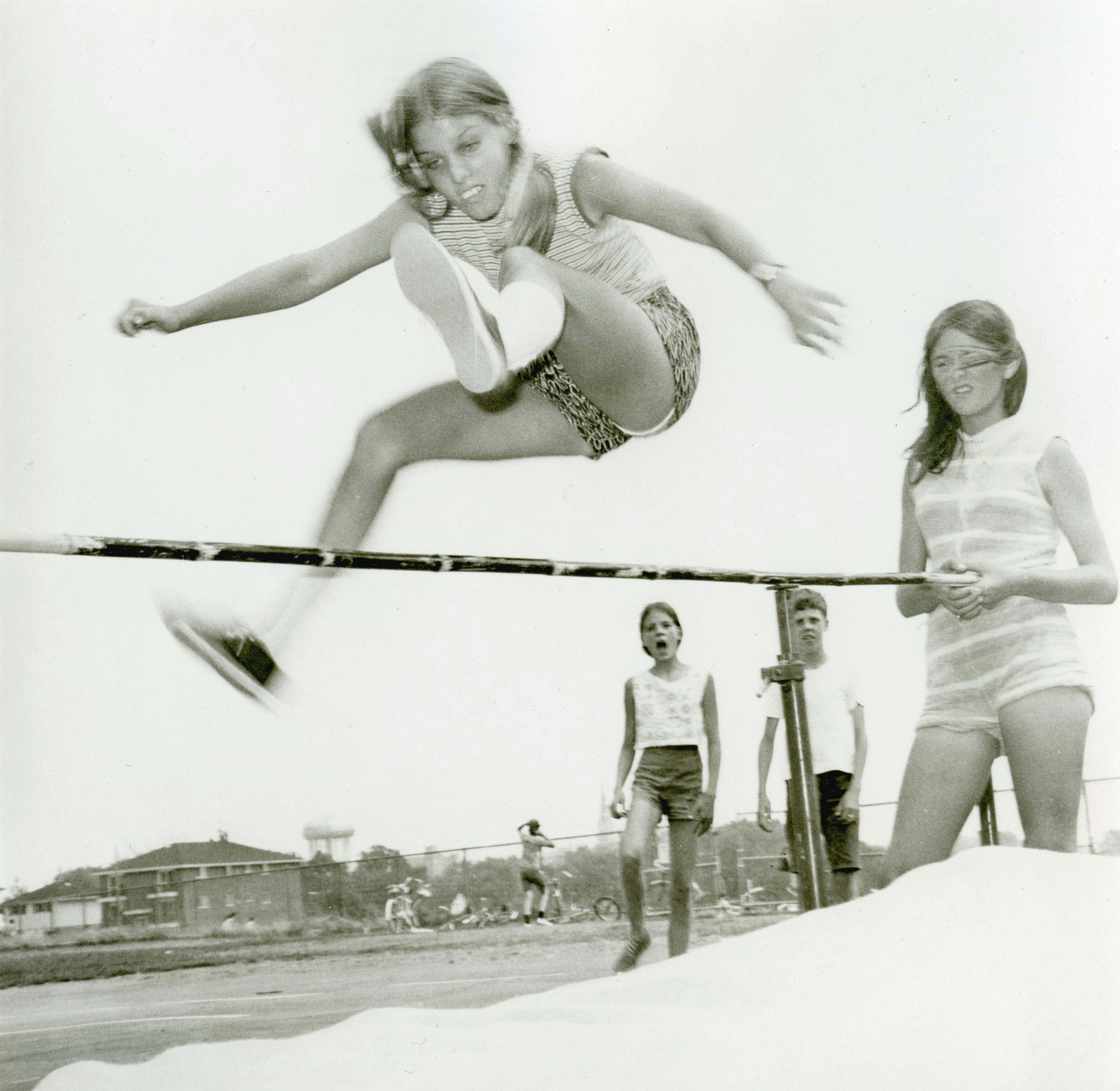 Young woman high jumping over a bar