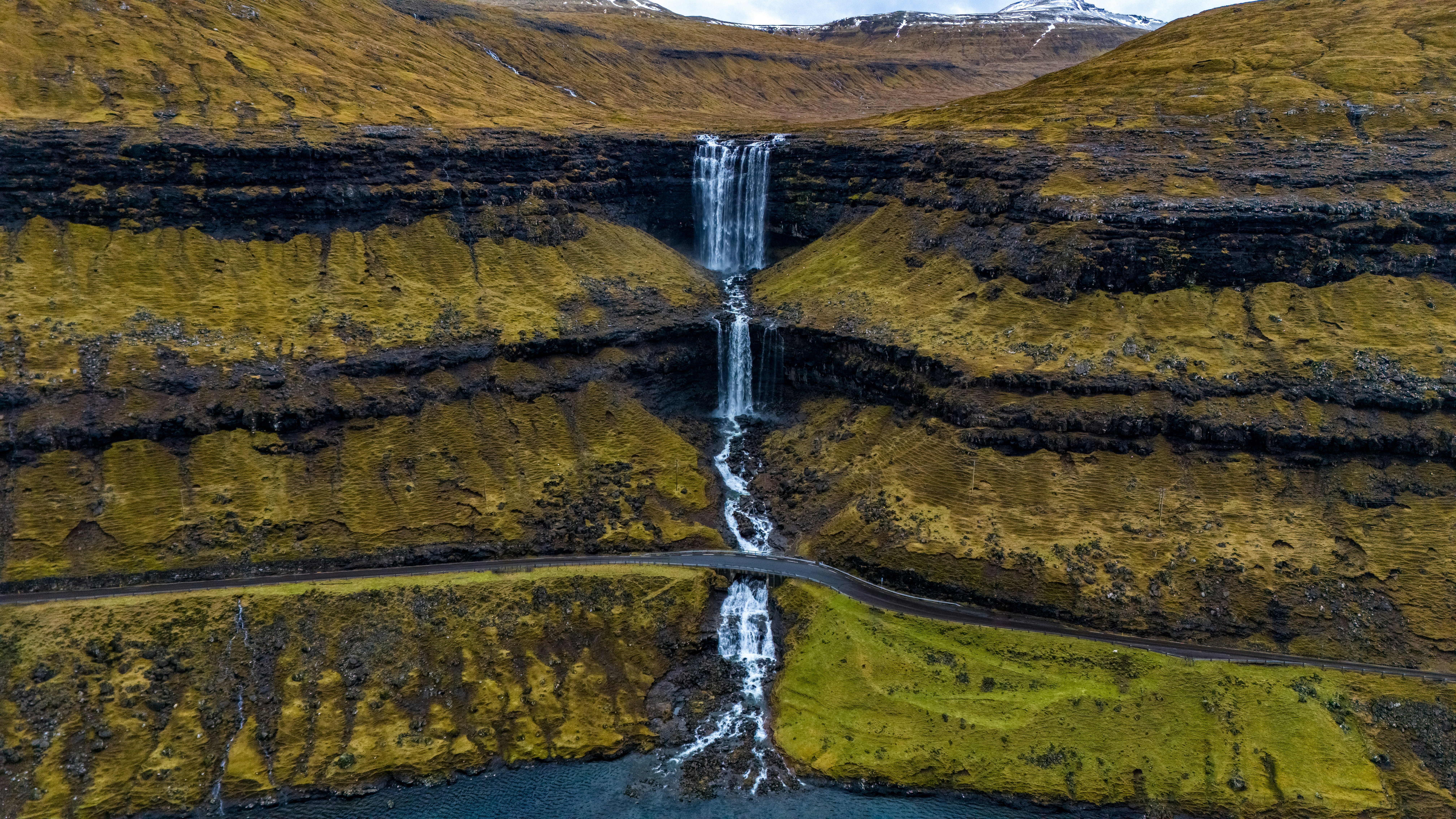 Ein Wasserfall stürzt eine geschichtete Klippe hinunter.