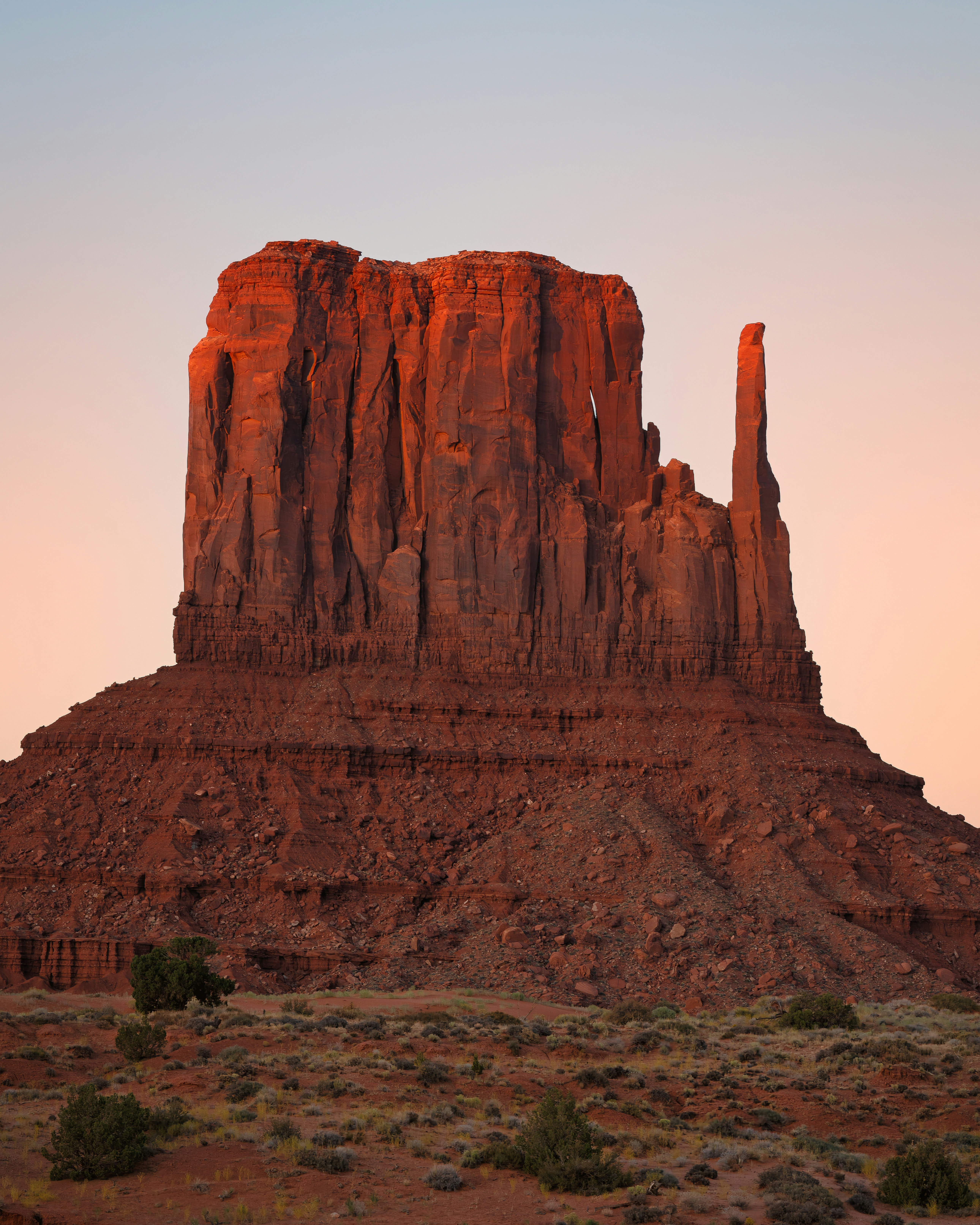 Monument valley's iconic butte glows in the sunset.
