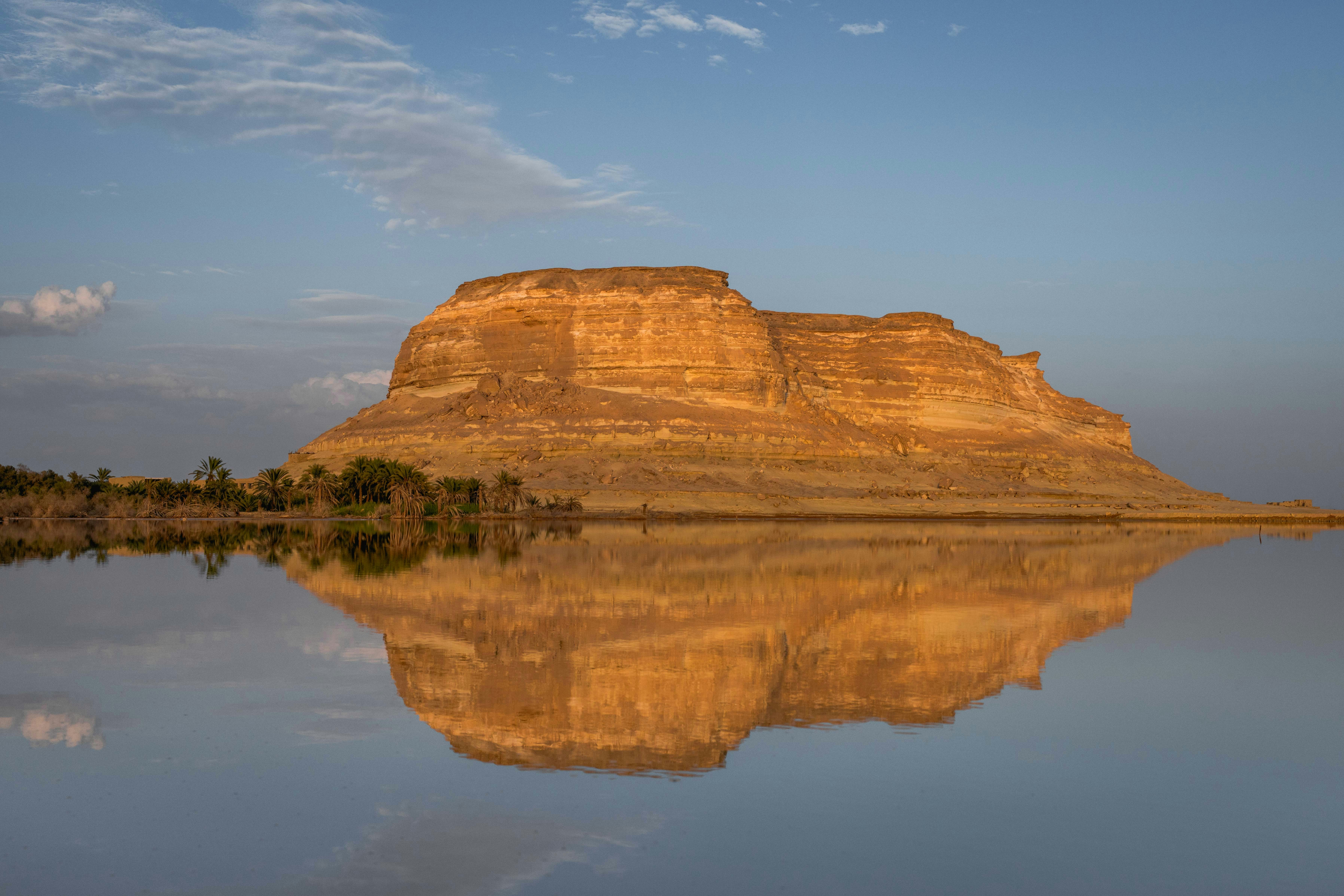 A rock formation reflects perfectly in the water.