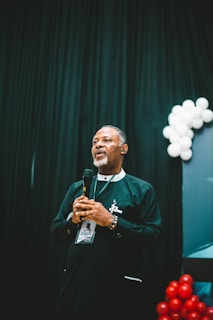 Man speaks into a microphone on stage.