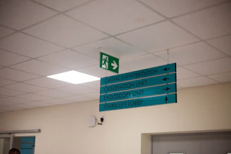 Hospital directional signs hang from the ceiling.