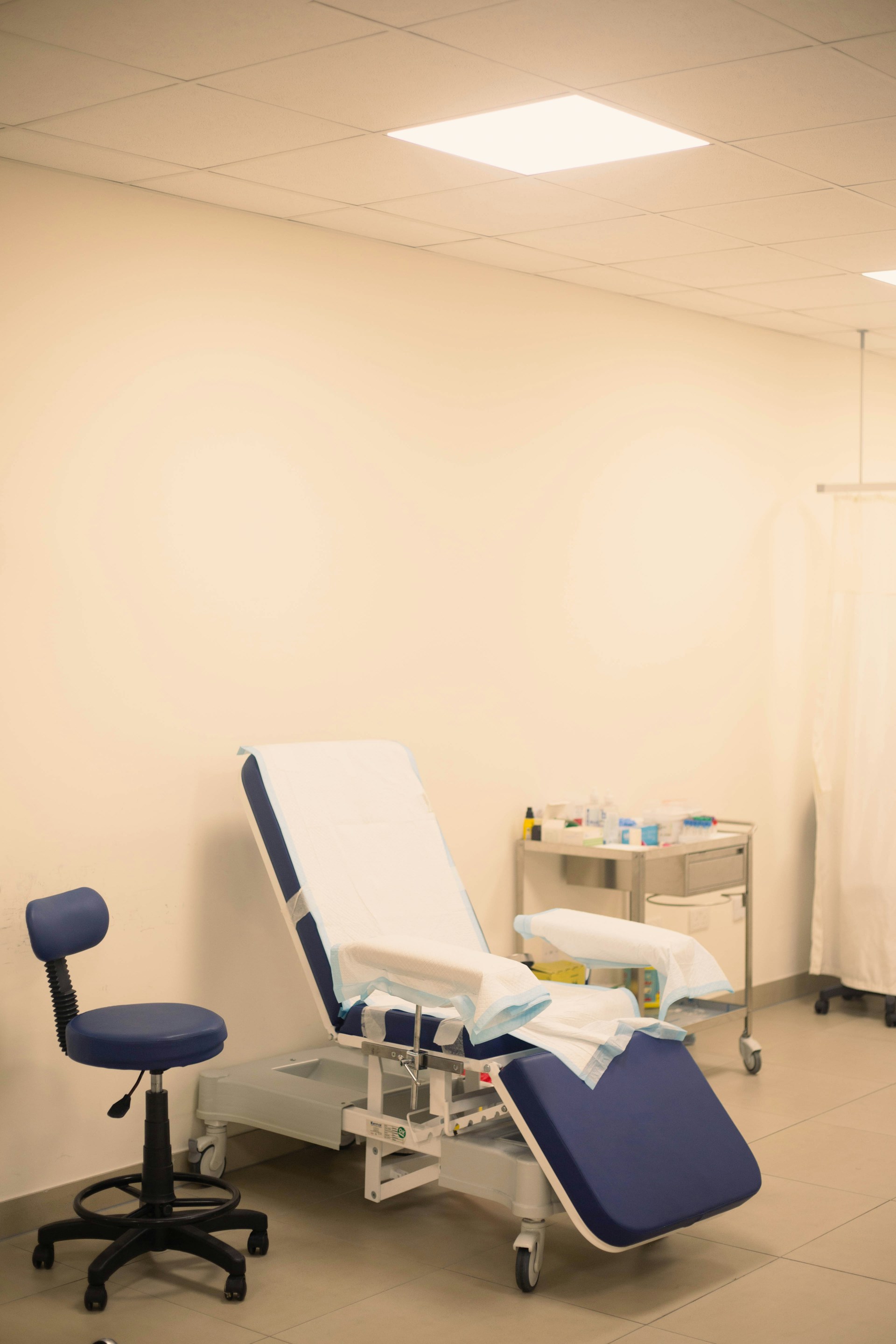 Examination room with chair and medical equipment.