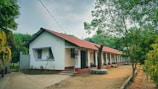 A white building with red roof sits outdoors.
