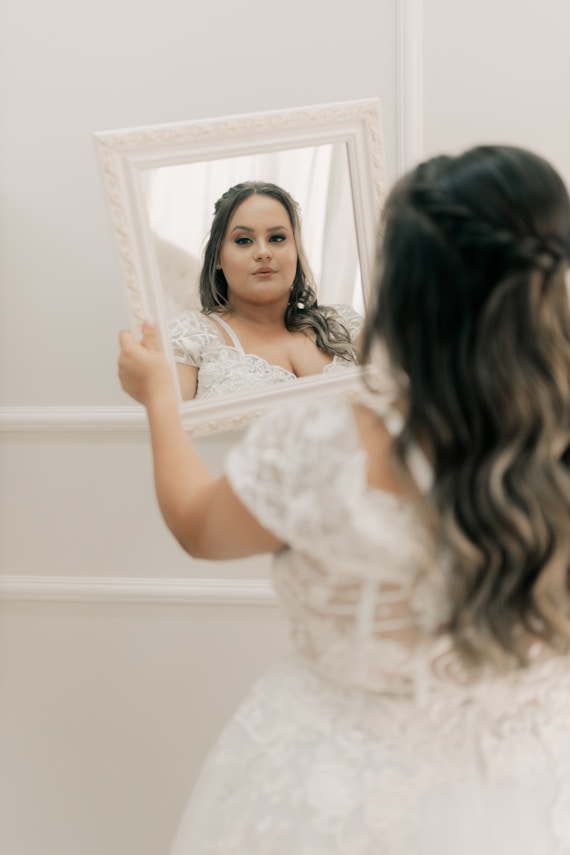 Bride admiring herself in the mirror on her wedding day.