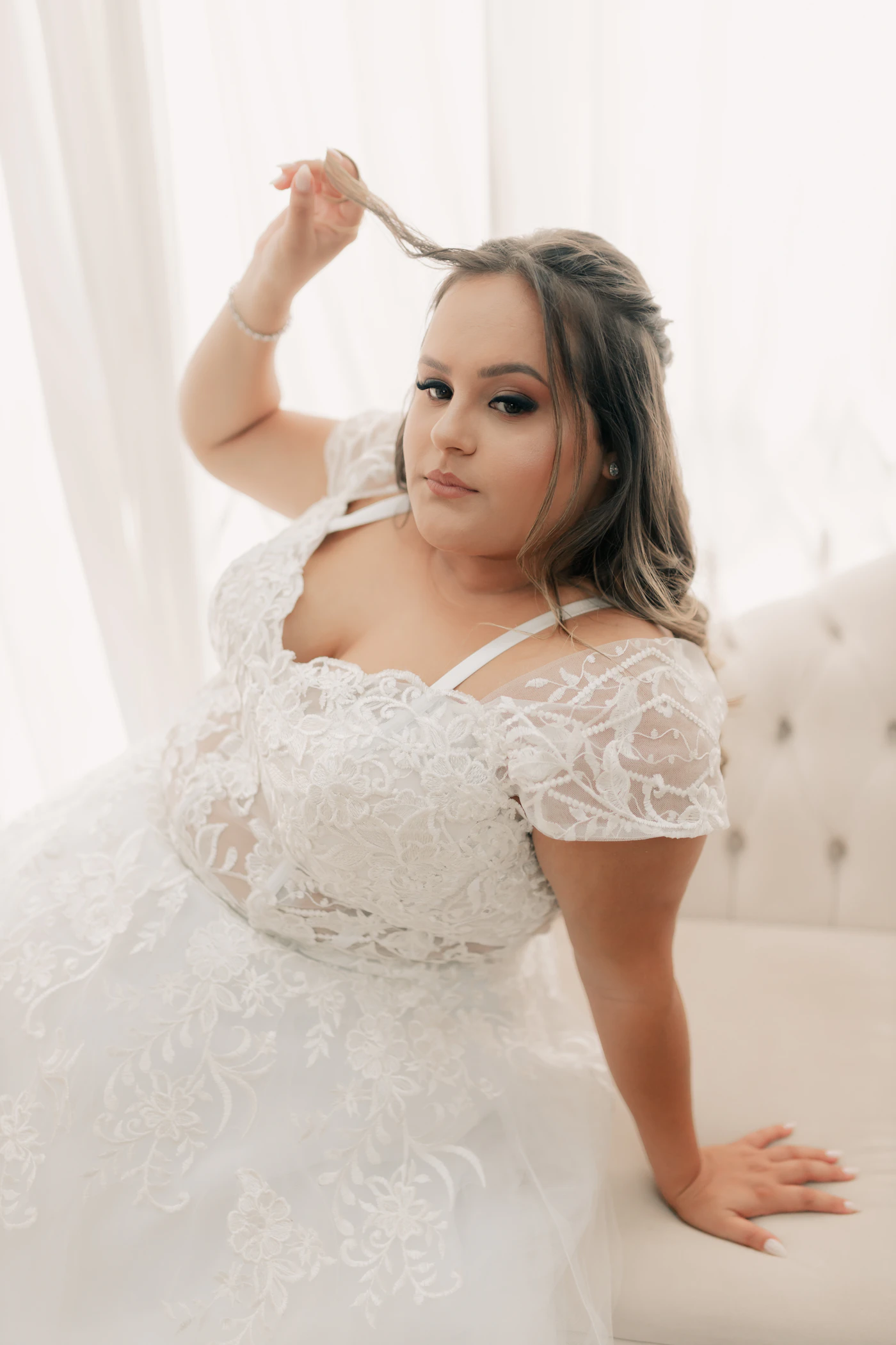 Affordable plus-size bridal gowns under $1,500 — A bride's hands holding a bouquet, with her wedding dress sleeve visible.