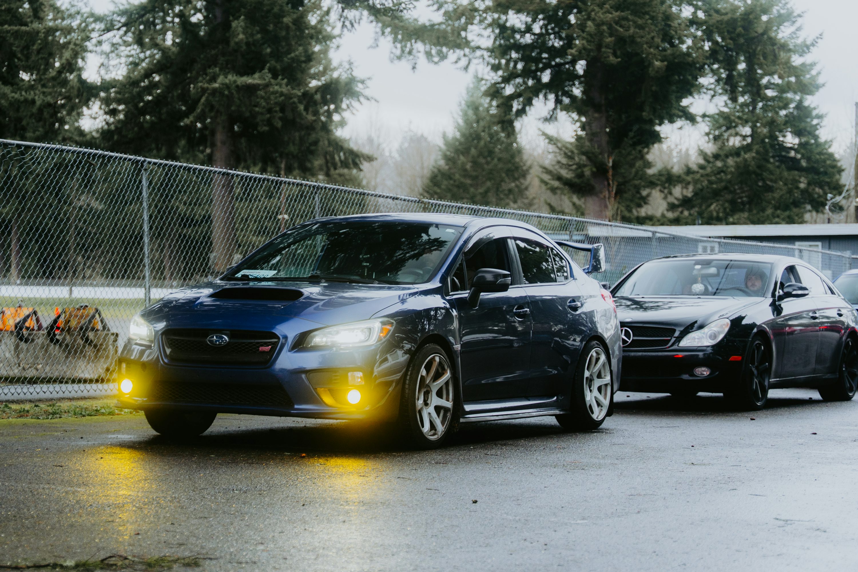 Two cars are parked near each other on a cloudy day.