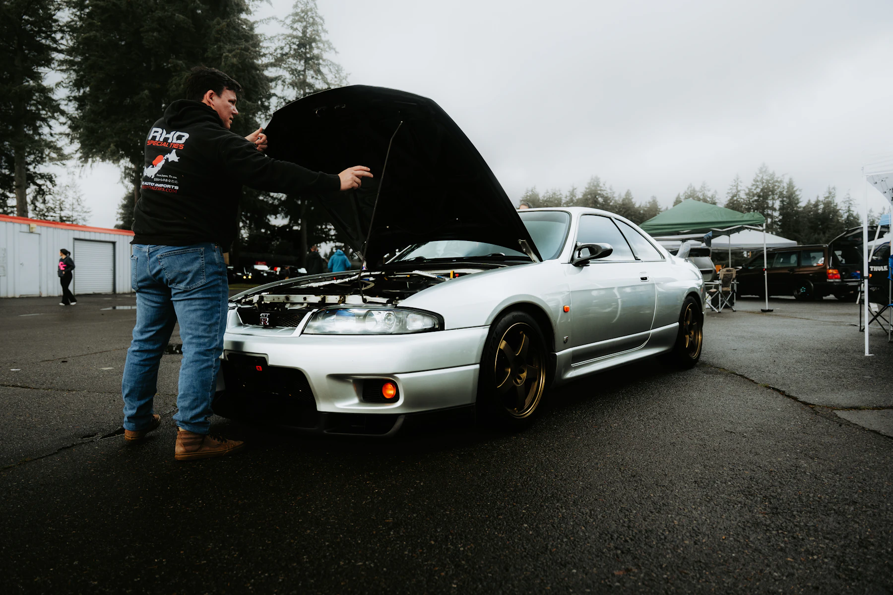 Τεχνικός εξετάζει ανοιχτό χώρο κινητήρα.