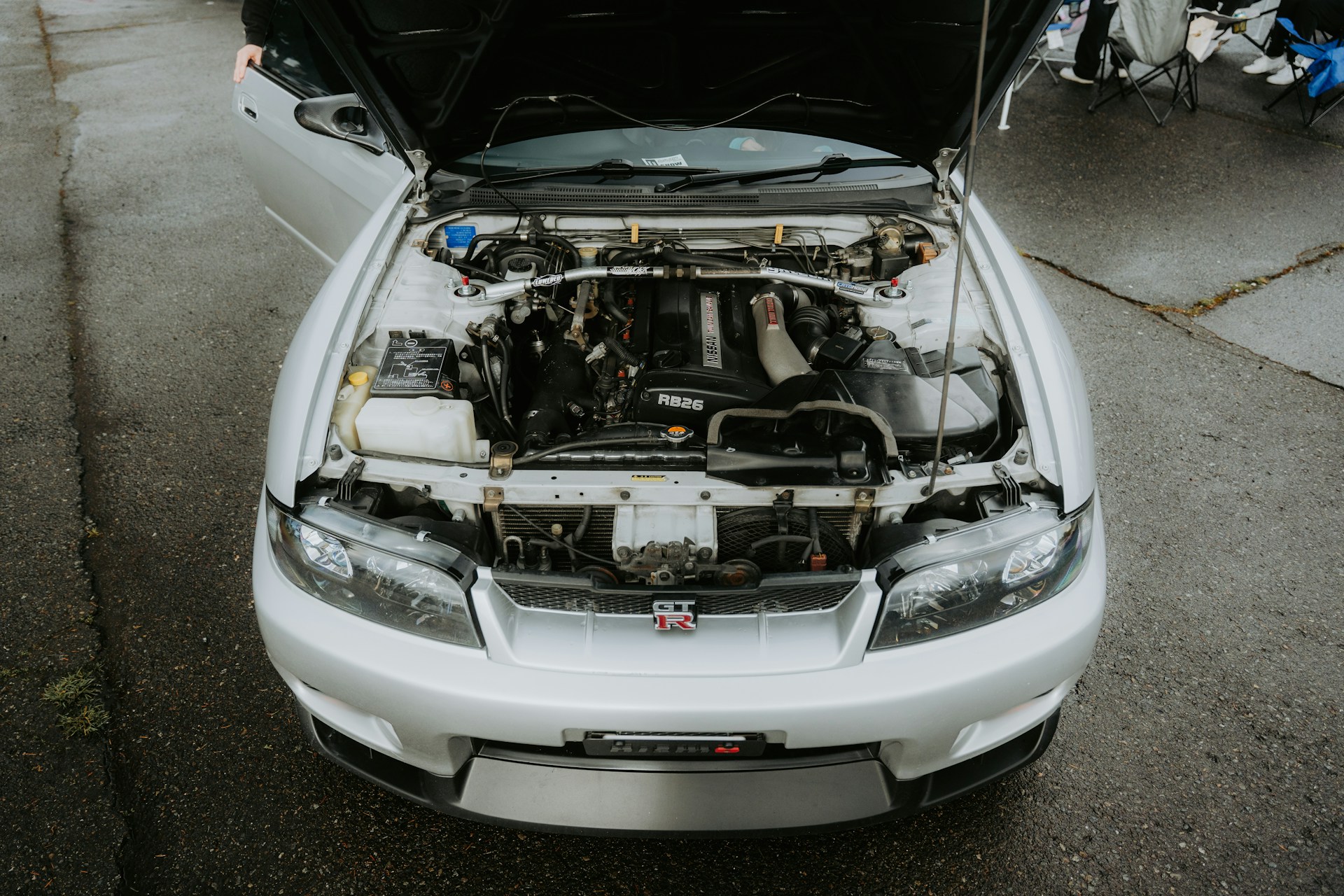 An open hood reveals the engine of a car.