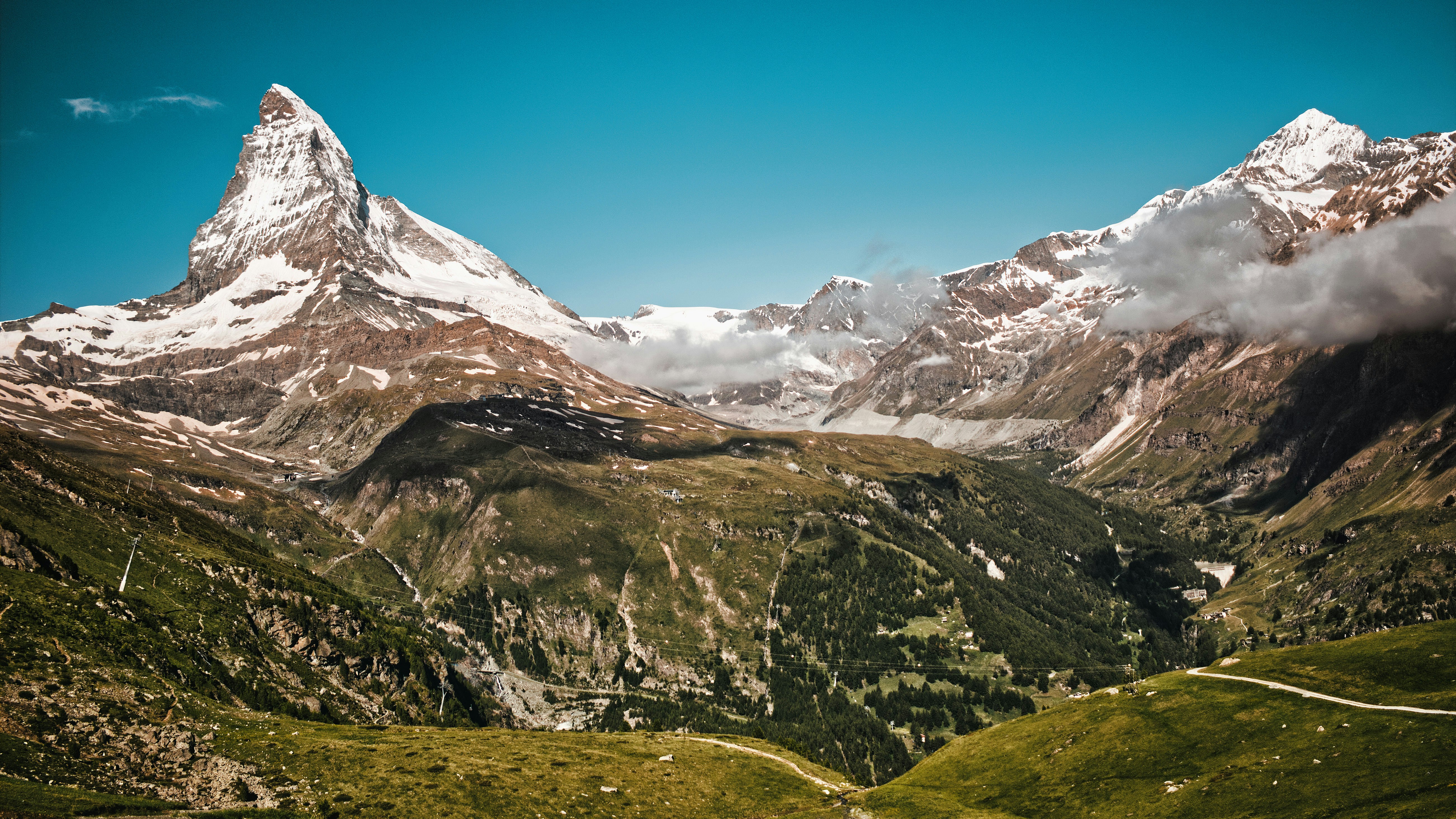 Majestic mountains rise against a bright, blue sky.