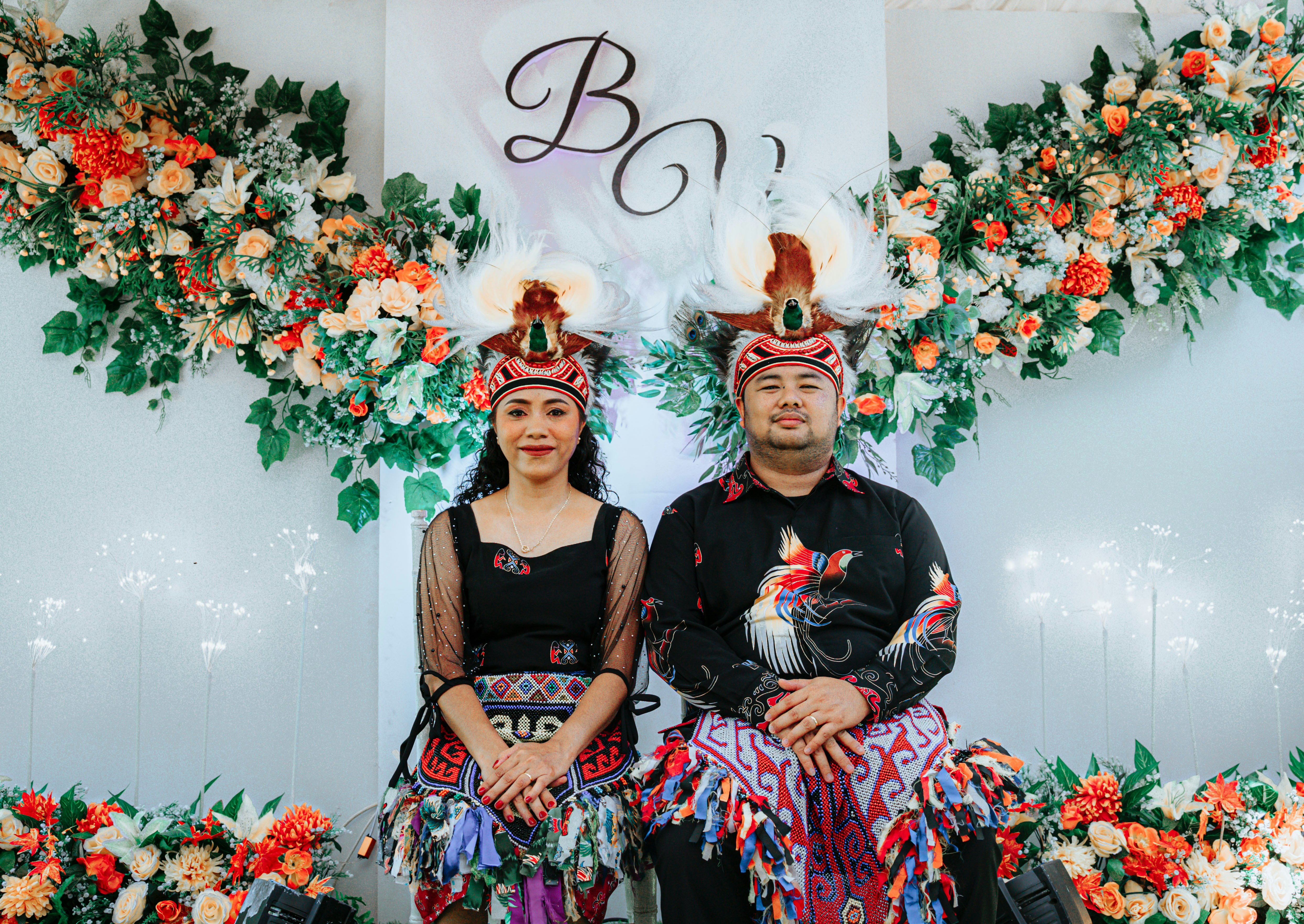 Pasangan dengan pakaian tradisional di pernikahan mereka.