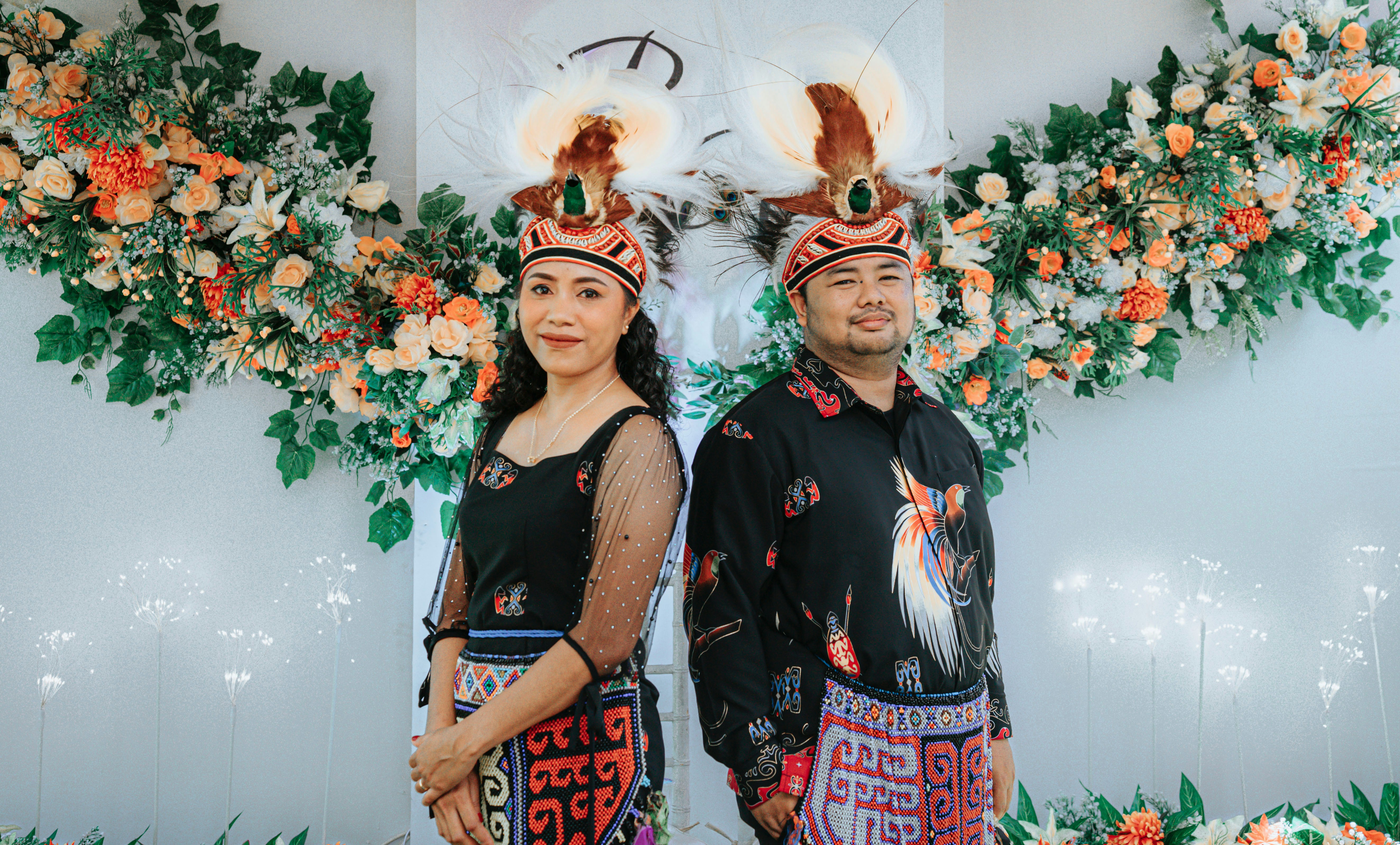 Sepasang suami istri berpose dengan pakaian pengantin tradisional.