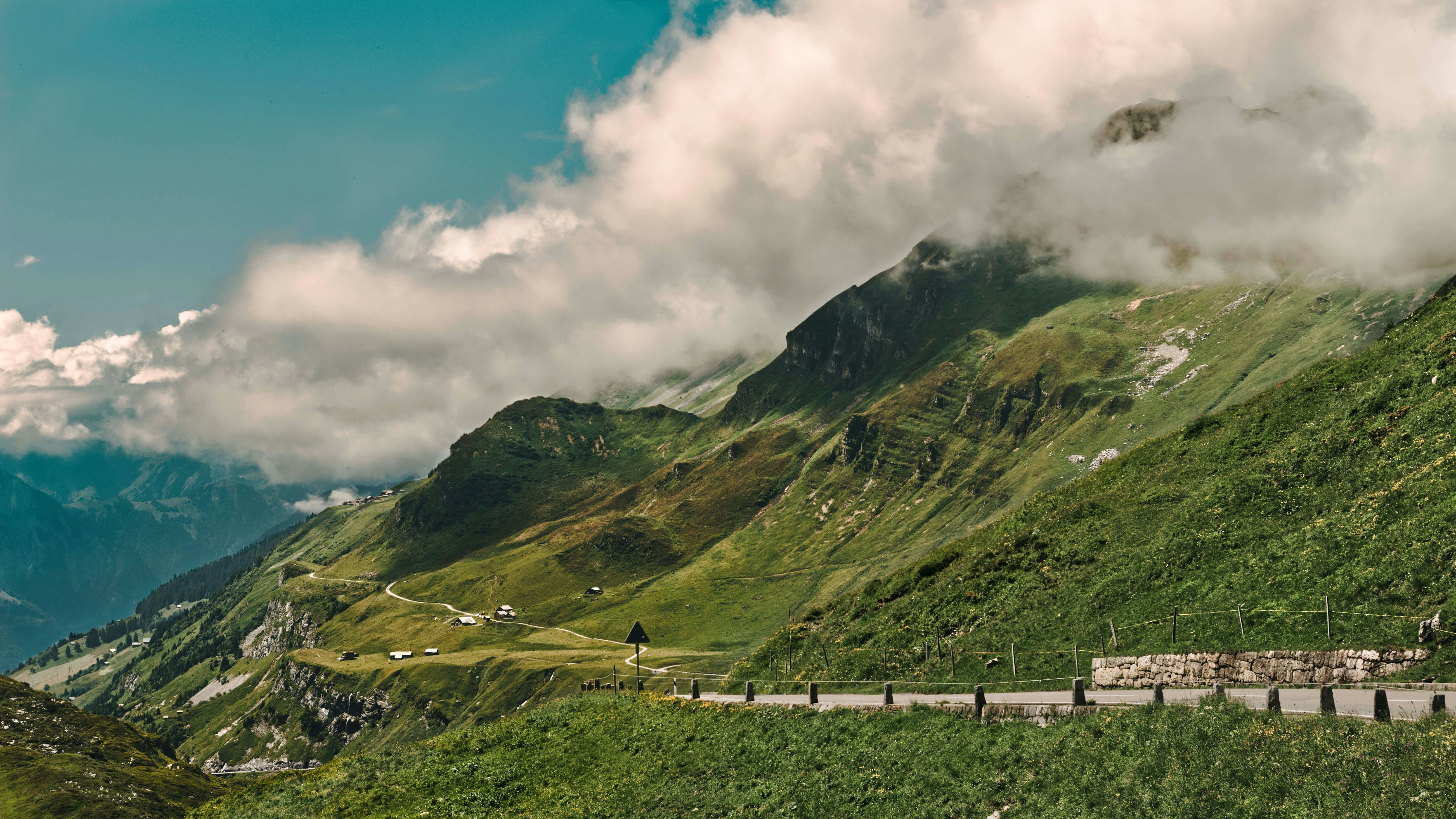 Green mountains rise under a cloudy sky.