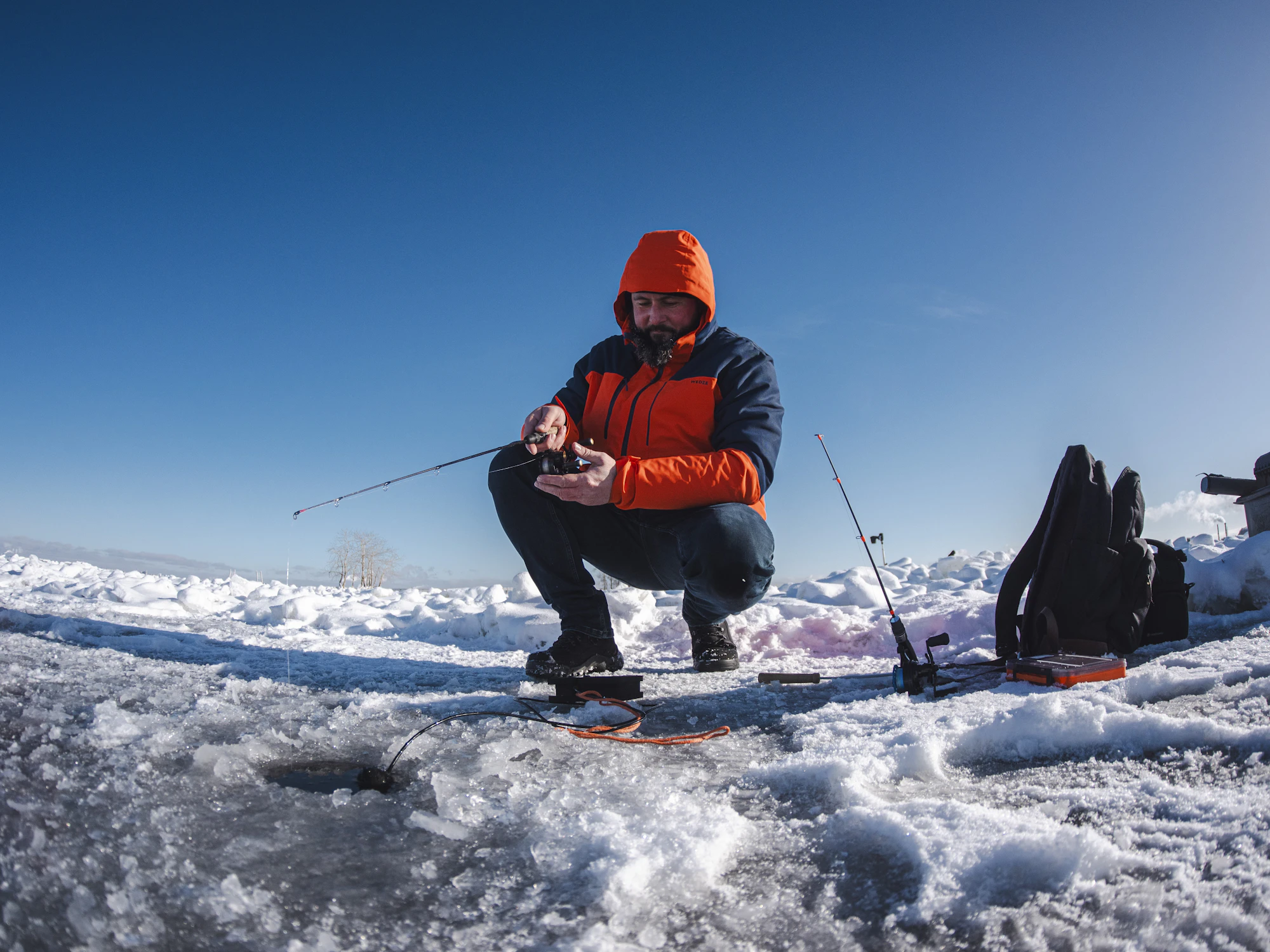 Angler ice fishing on a frozen lake