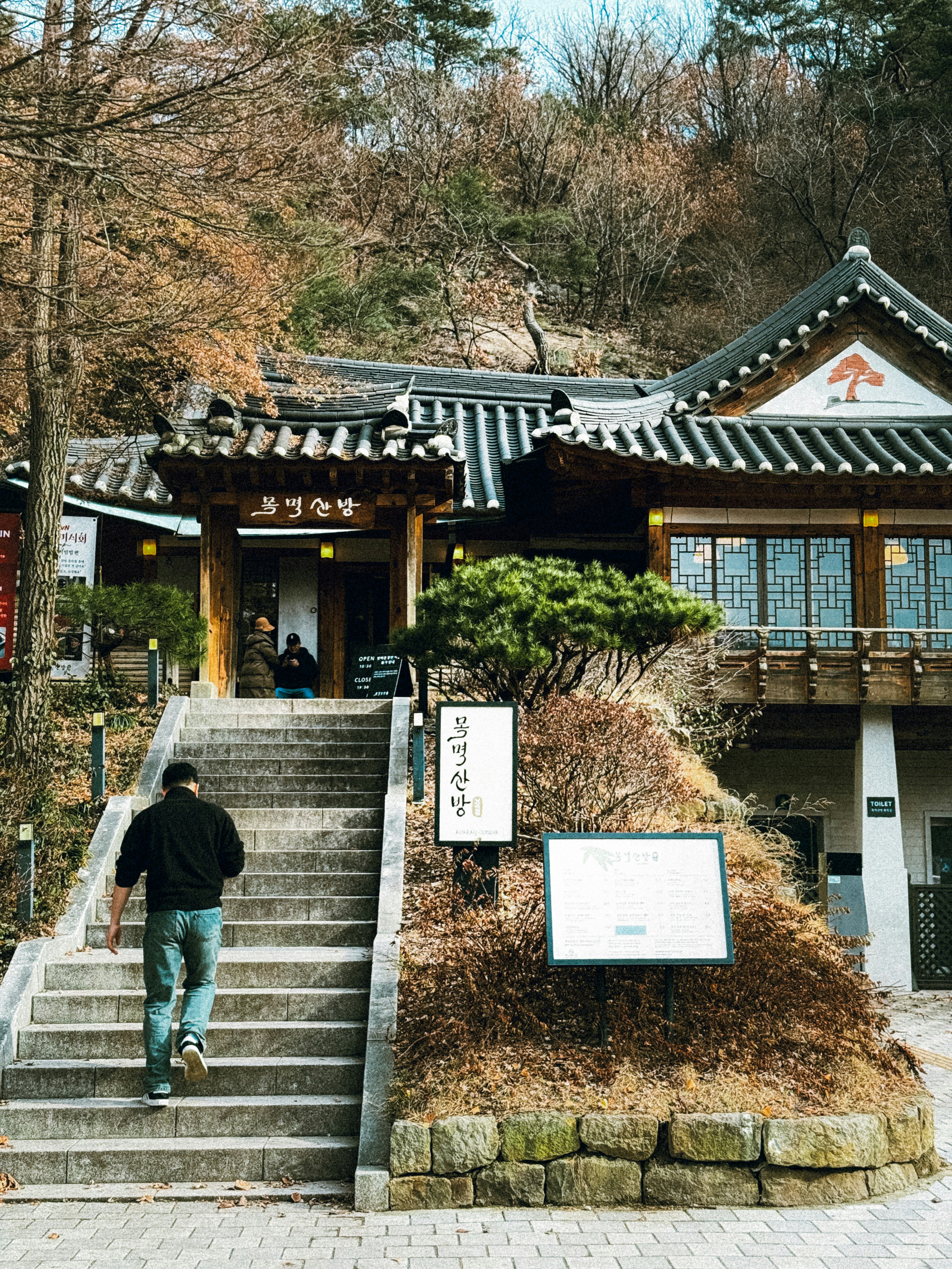 A man walks up stairs to traditional building.