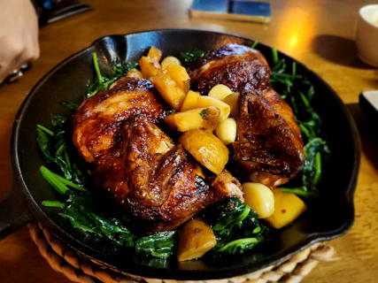 Roasted chicken and potatoes served on a bed of greens.