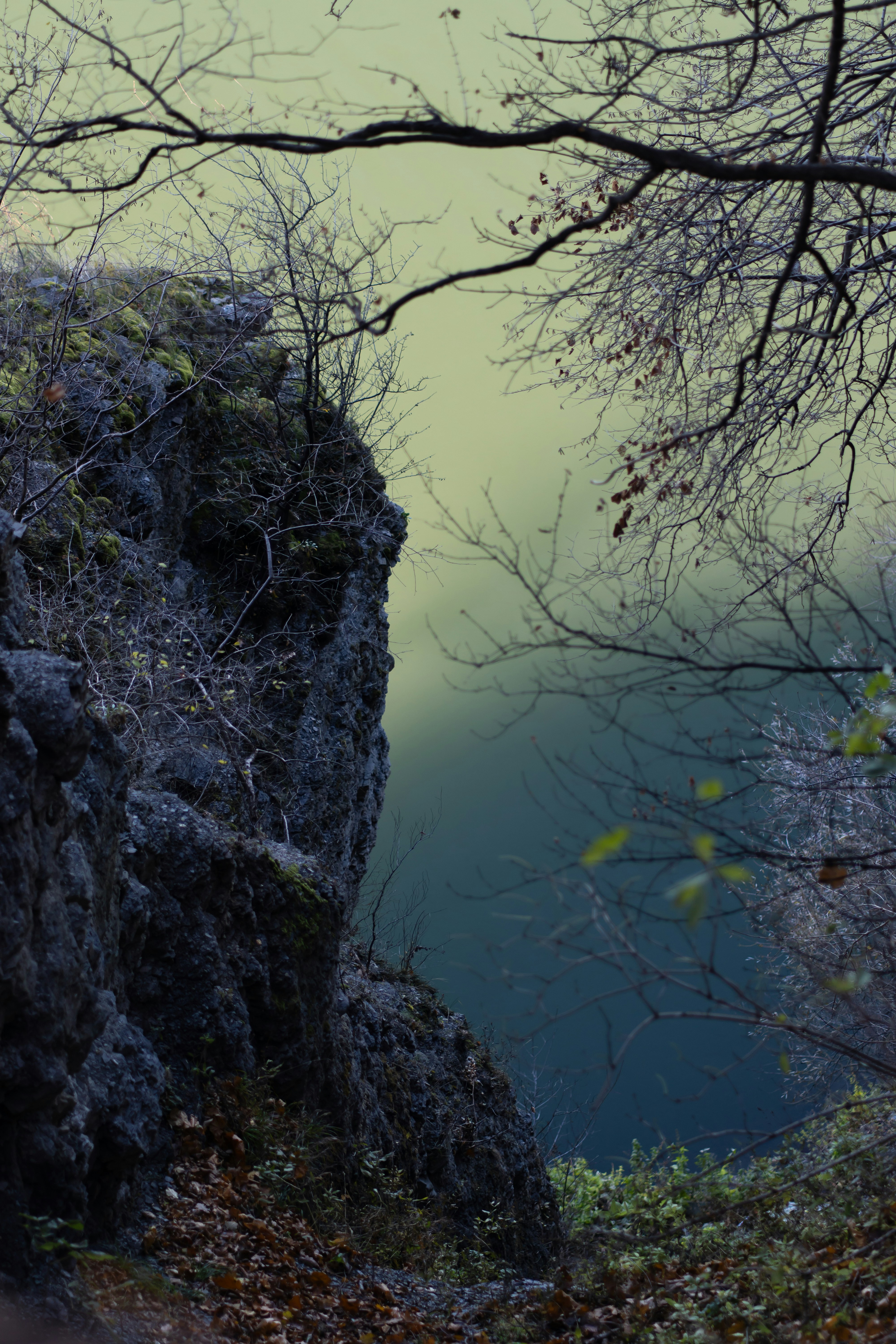 Blick auf die Klippe über ein dunkles, nebliges Gewässer.
