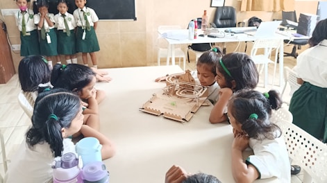 Children admire a model displayed on a table.