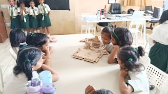 Children admire a model displayed on a table.
