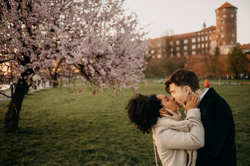 Couple shares a kiss with a castle in the background.