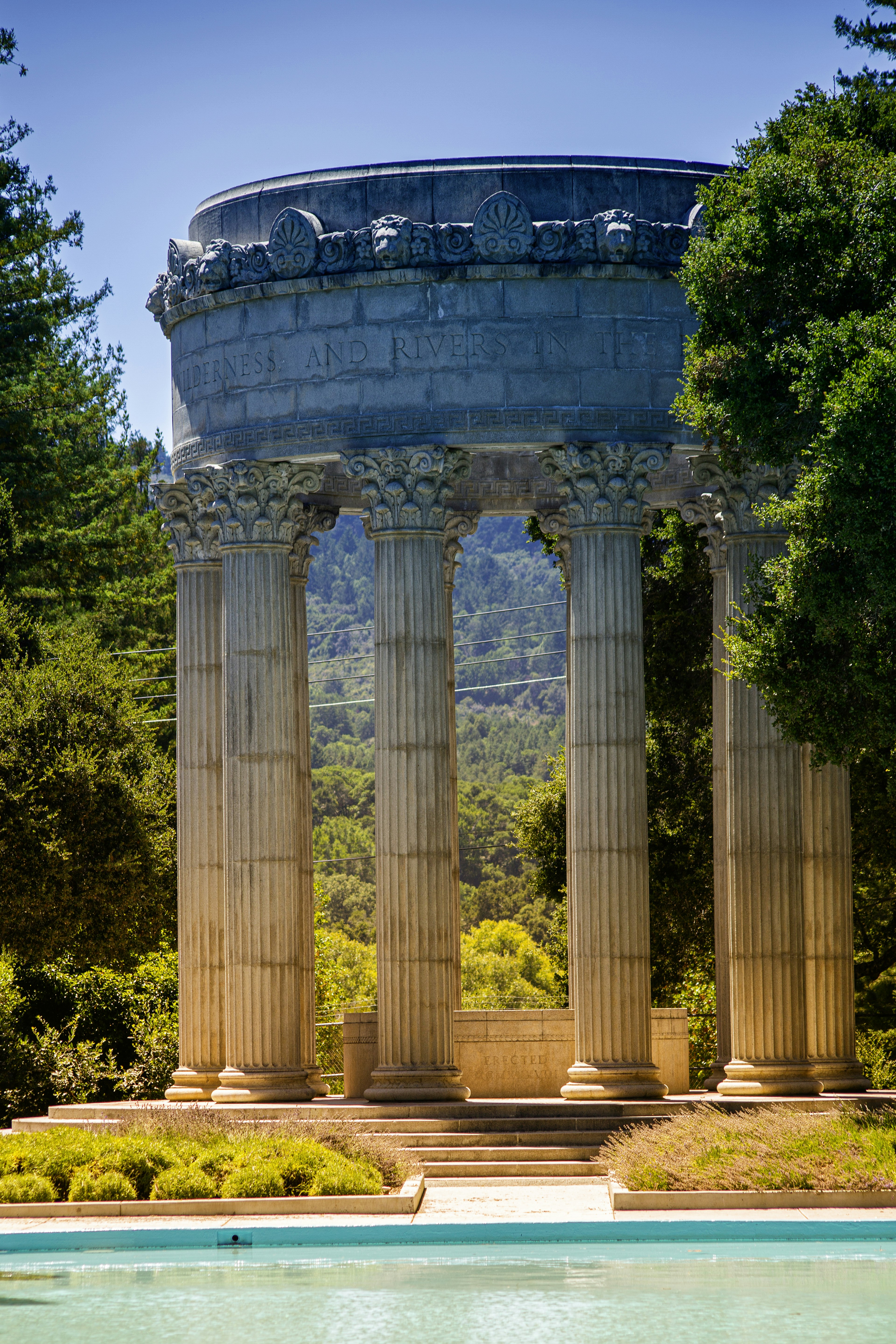 Classic columns stand near a pool of water.