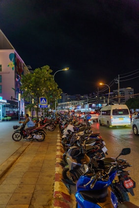 Motorbikes parked along a street at night.