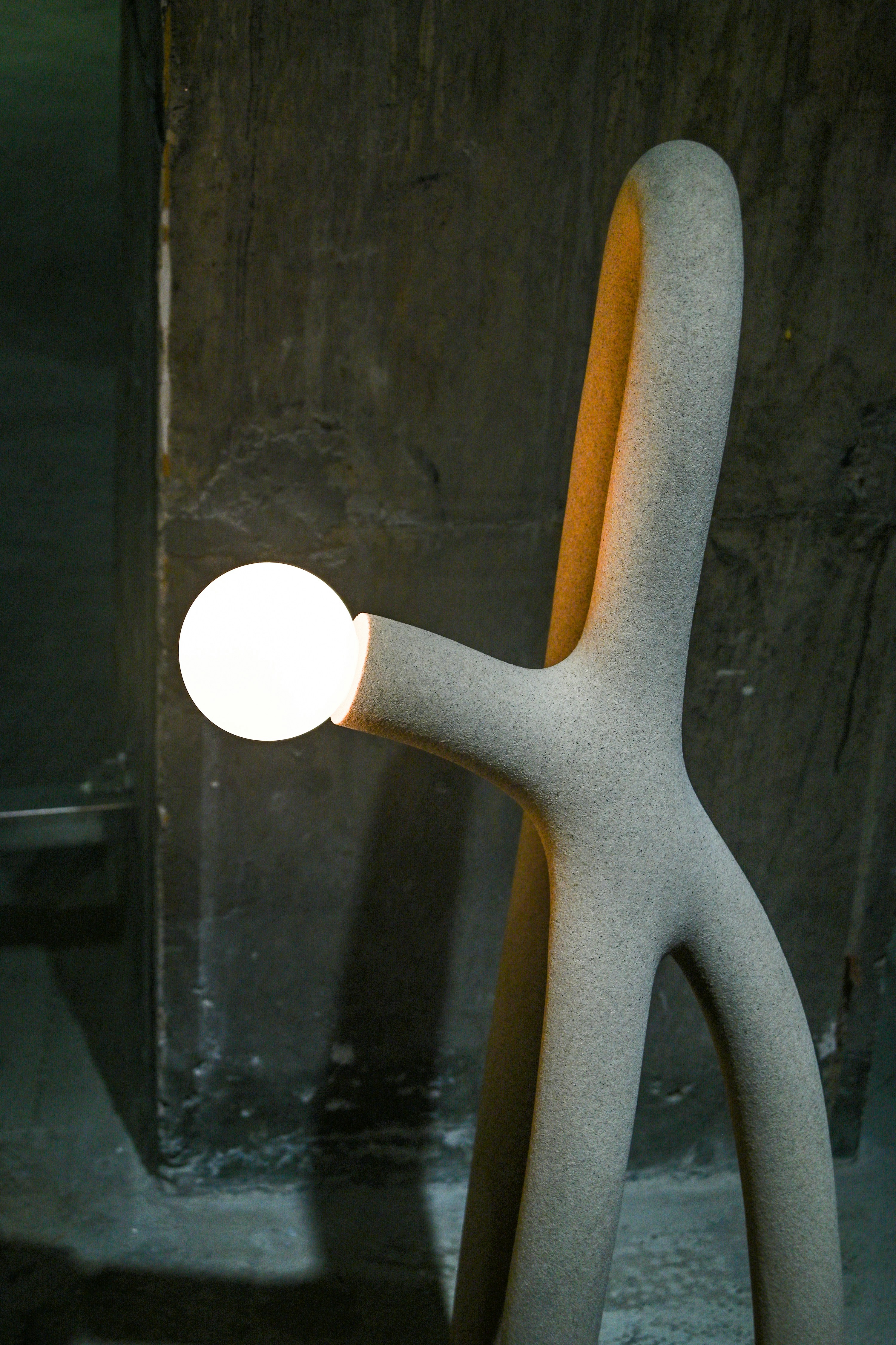 Abstract, modern lamp with a glowing orb.