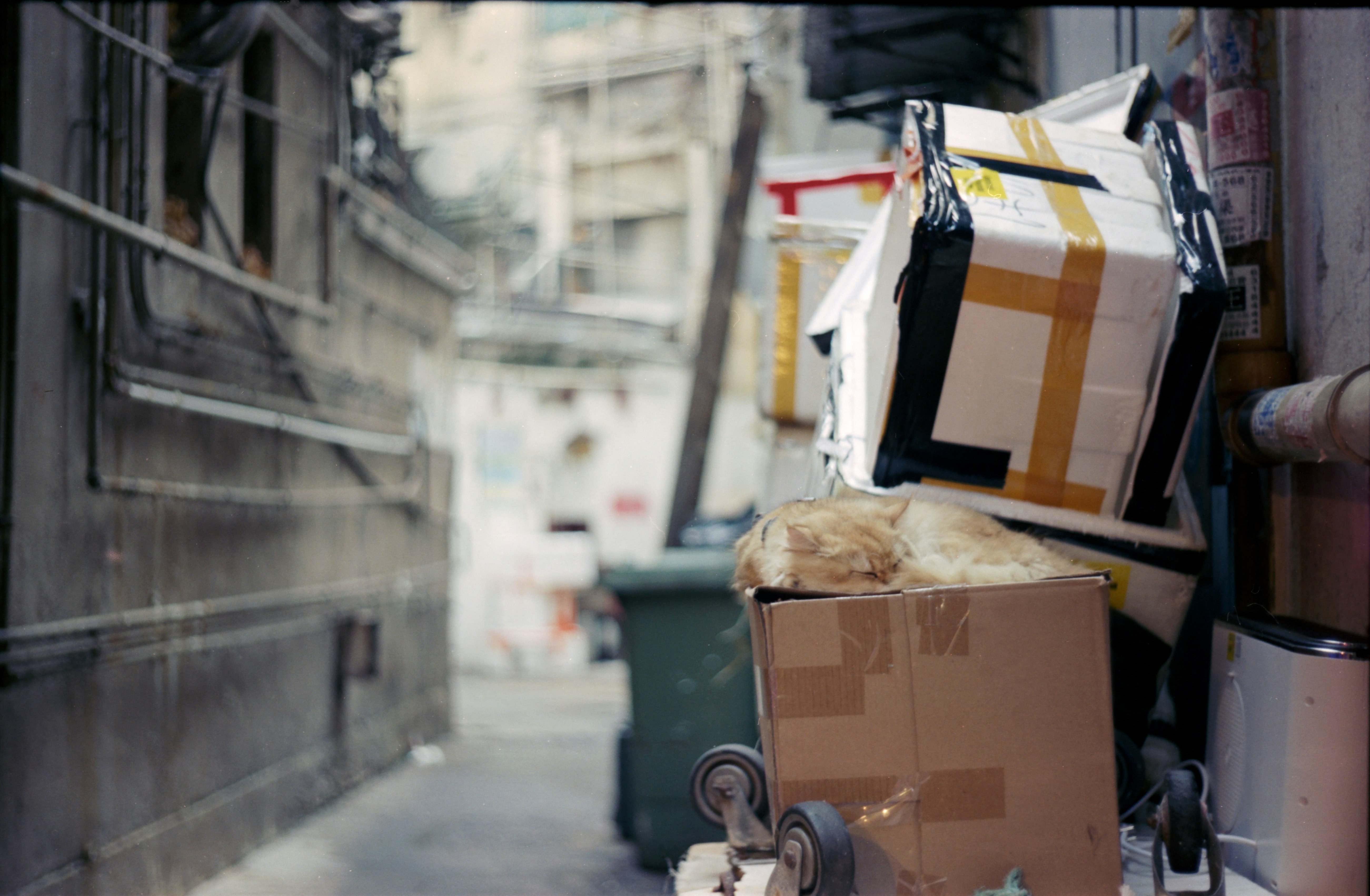 Boxes are piled up in a city alleyway.