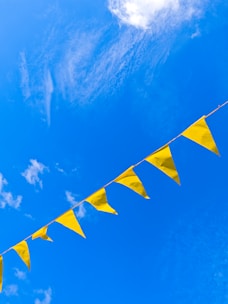 Yellow pennant flags against a vibrant blue sky.