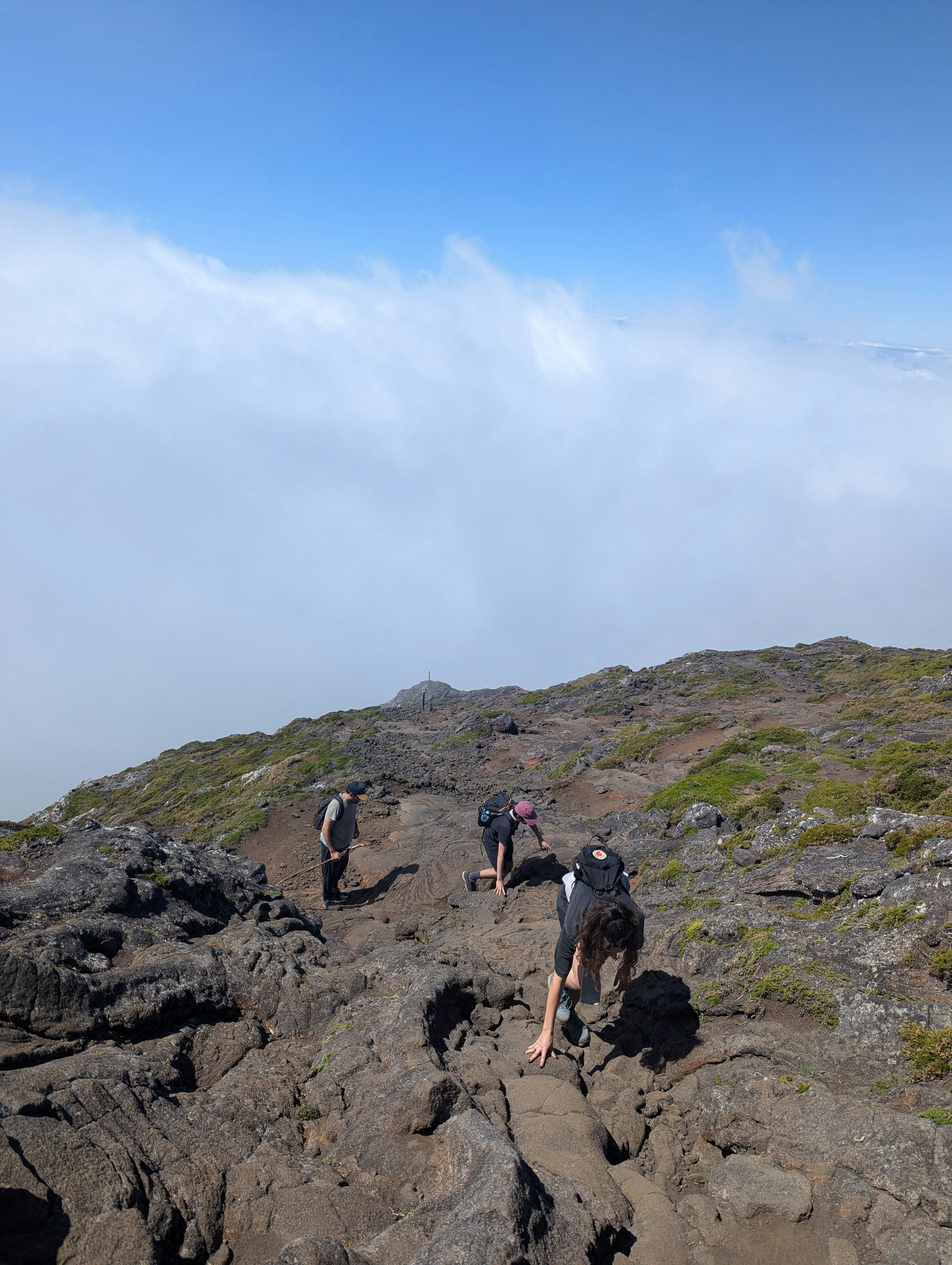 People are hiking up a rocky mountain.