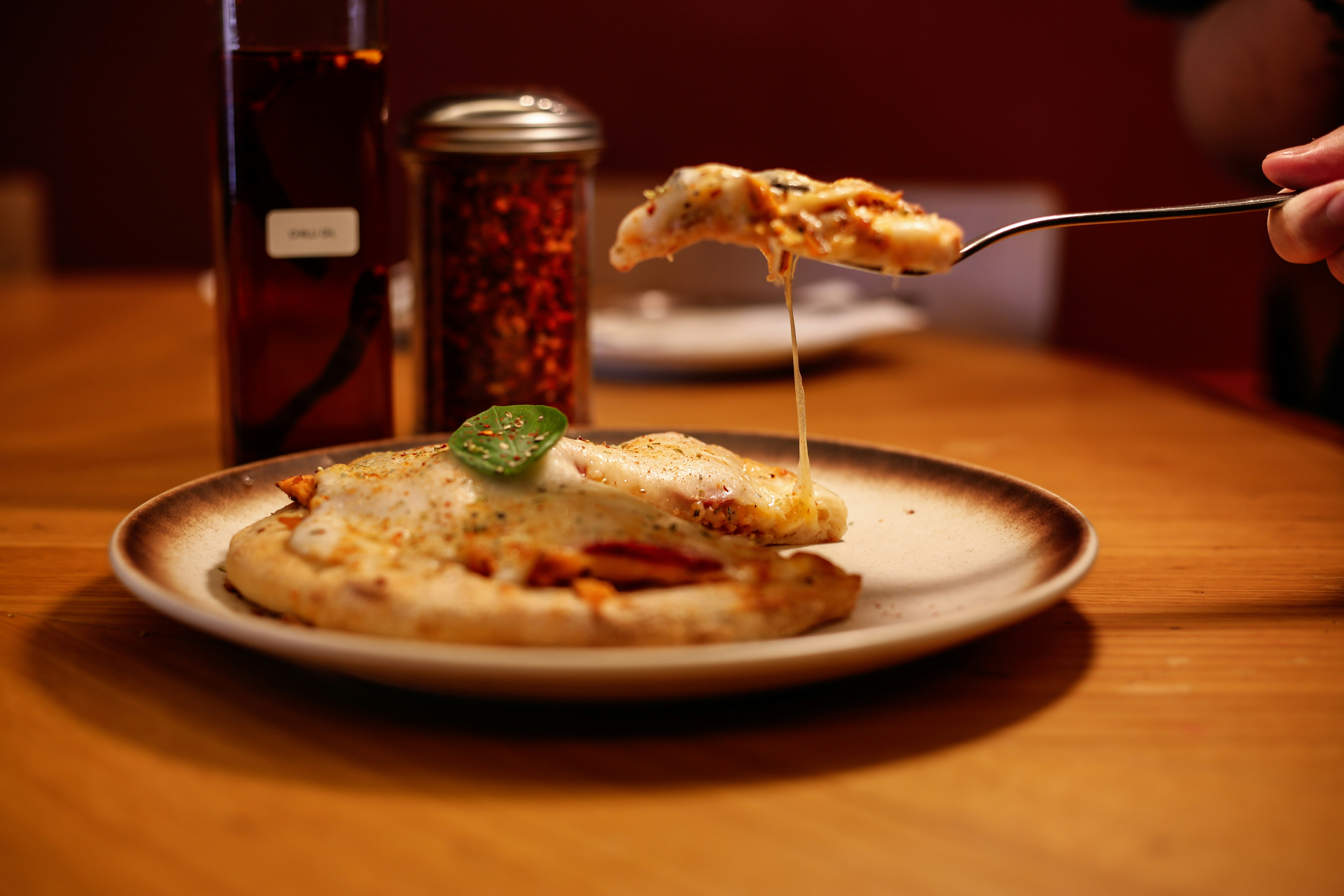 Pizza with melted cheese is being lifted.