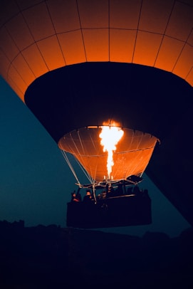 Hot air balloon igniting flames at night.