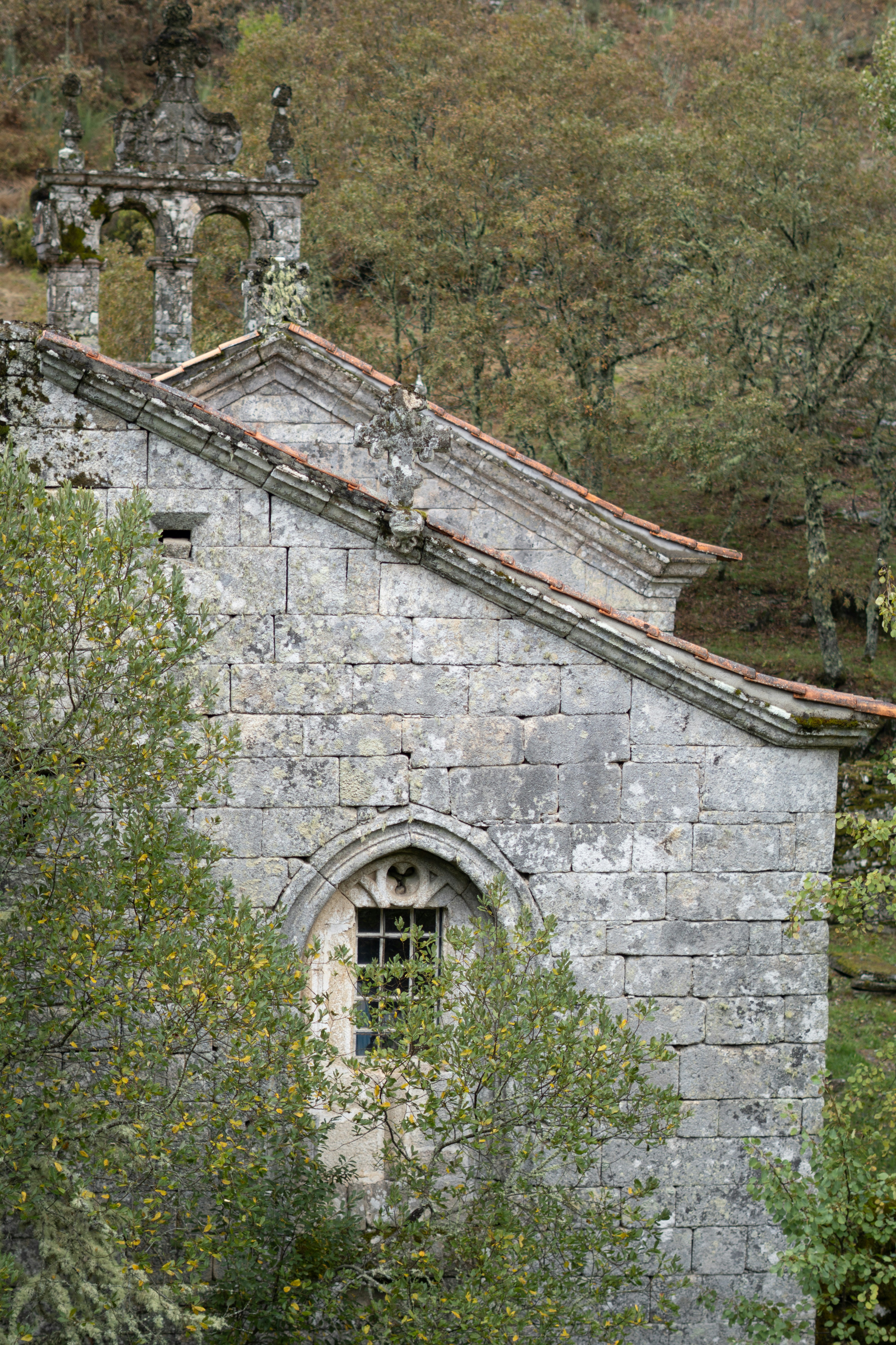 An old stone building sits among lush green trees.
