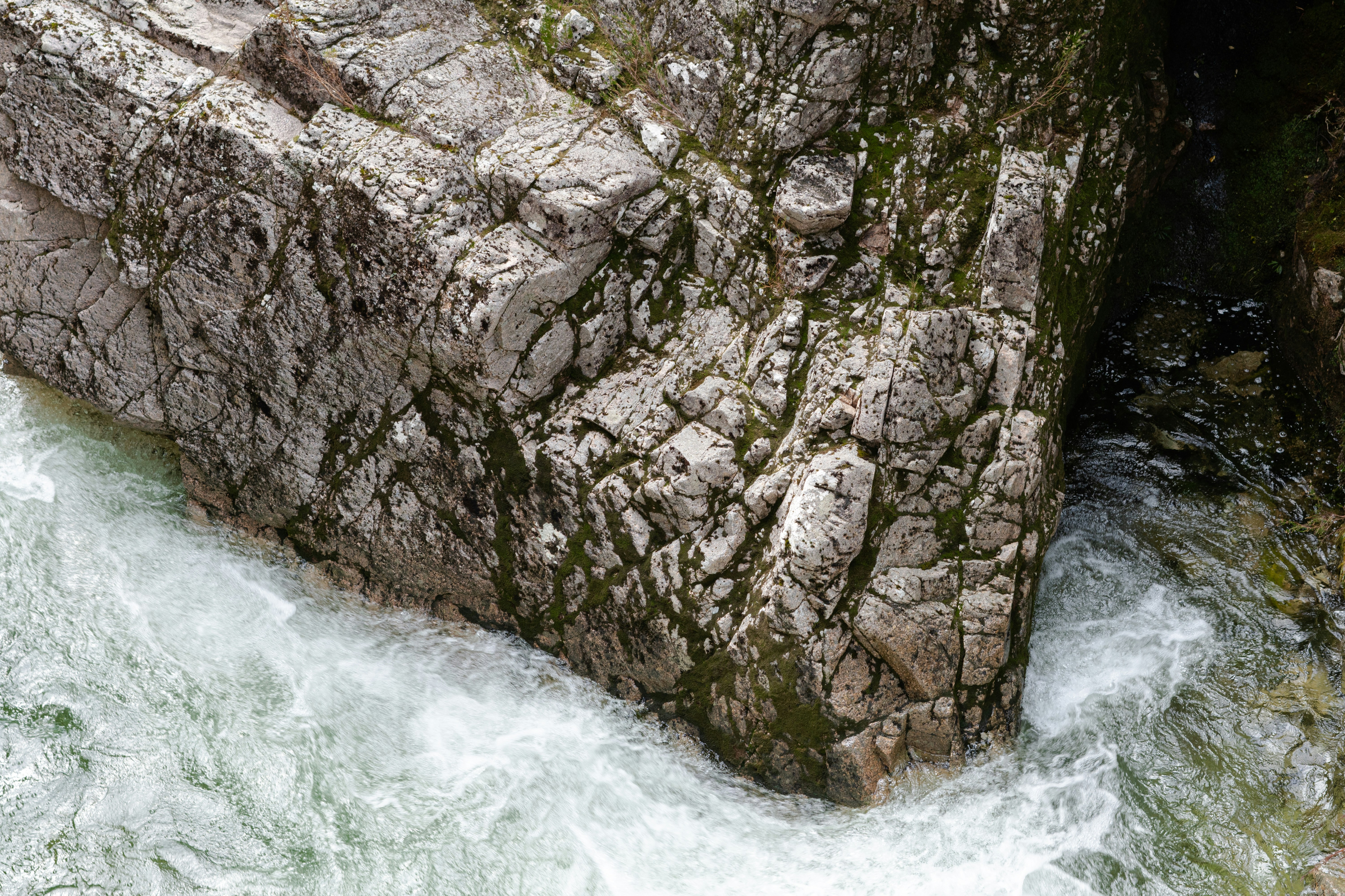 Water crashes around a large, jagged rock.