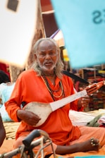 An older man is playing a stringed instrument.