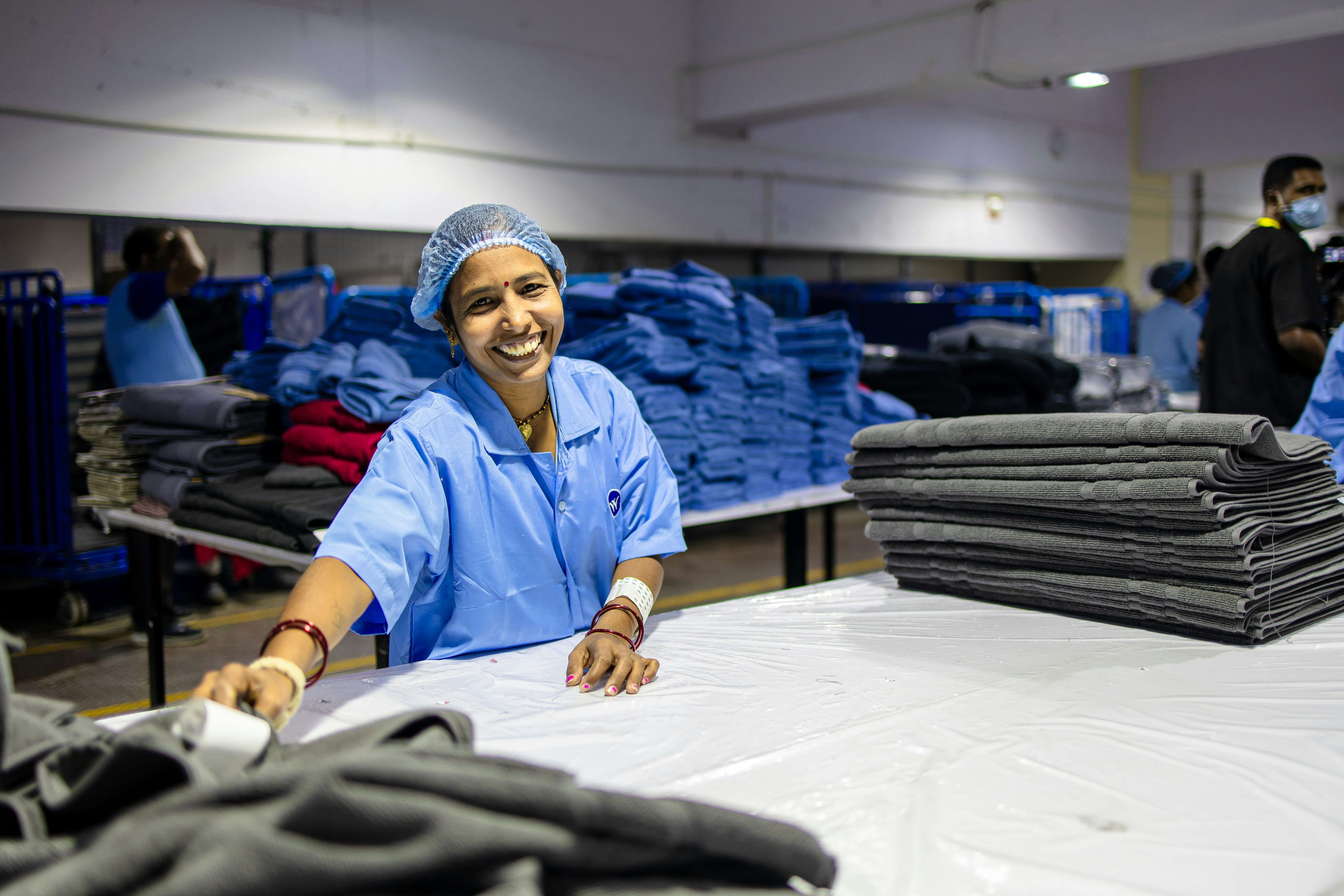 Un ouvrier d’usine sourit en organisant le tissu.