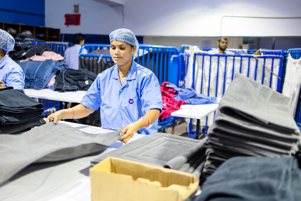 A worker folding finished garments on the production line