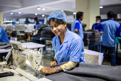 Woman uses a sewing machine in a factory.