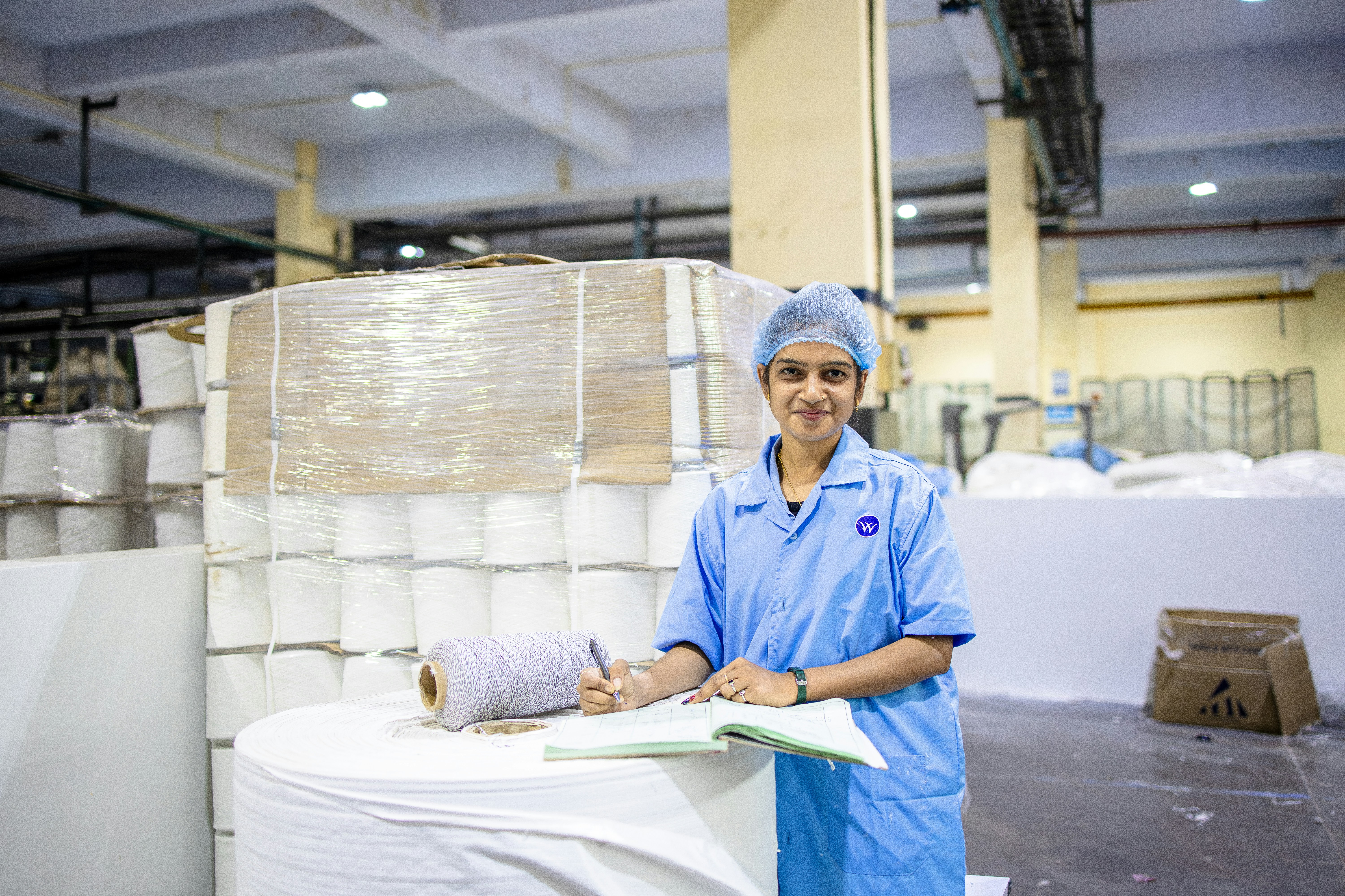 Frau arbeitet in einem Lagerhaus einer Papierfabrik.