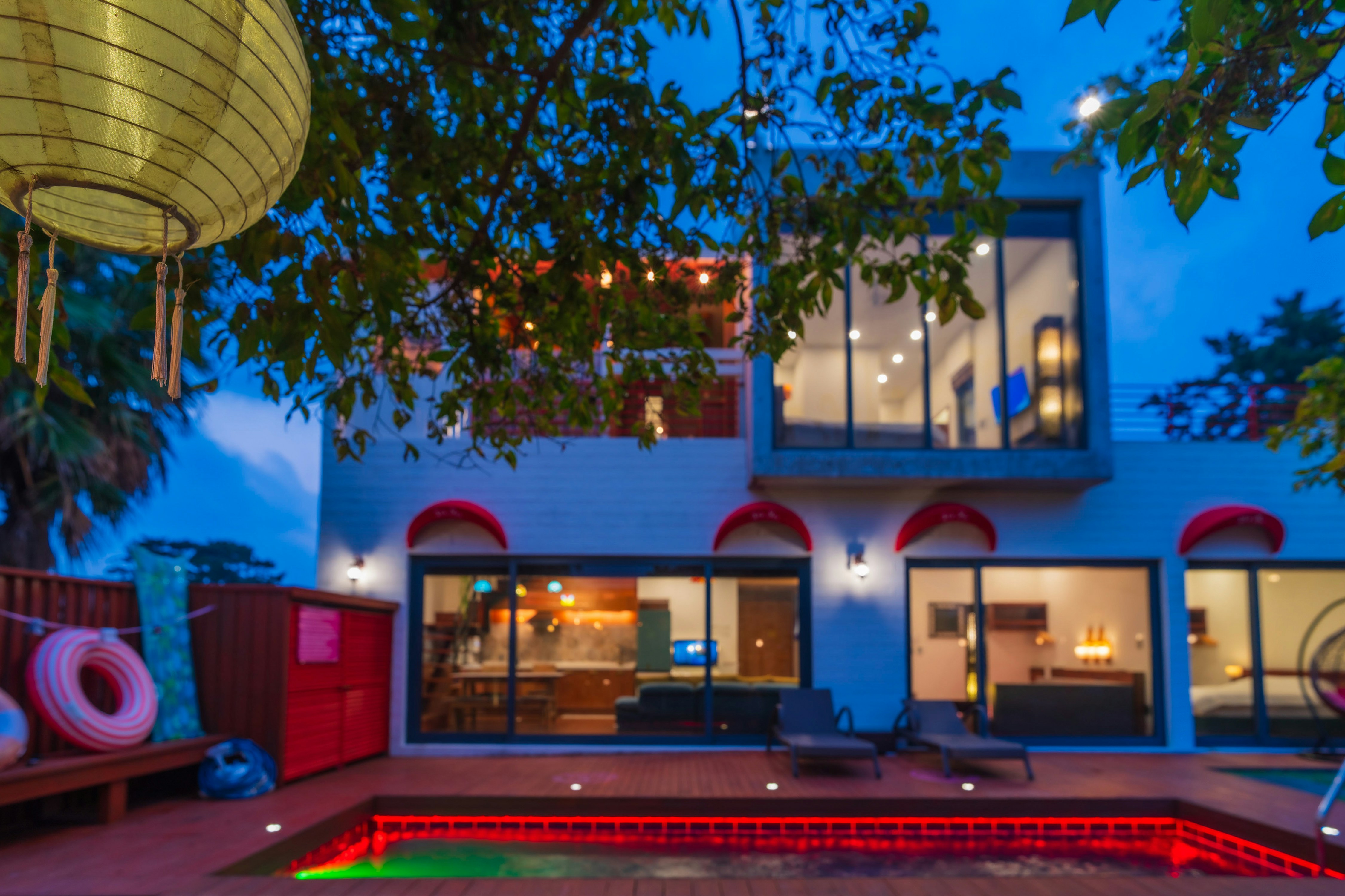 A luxurious house with a pool at dusk.