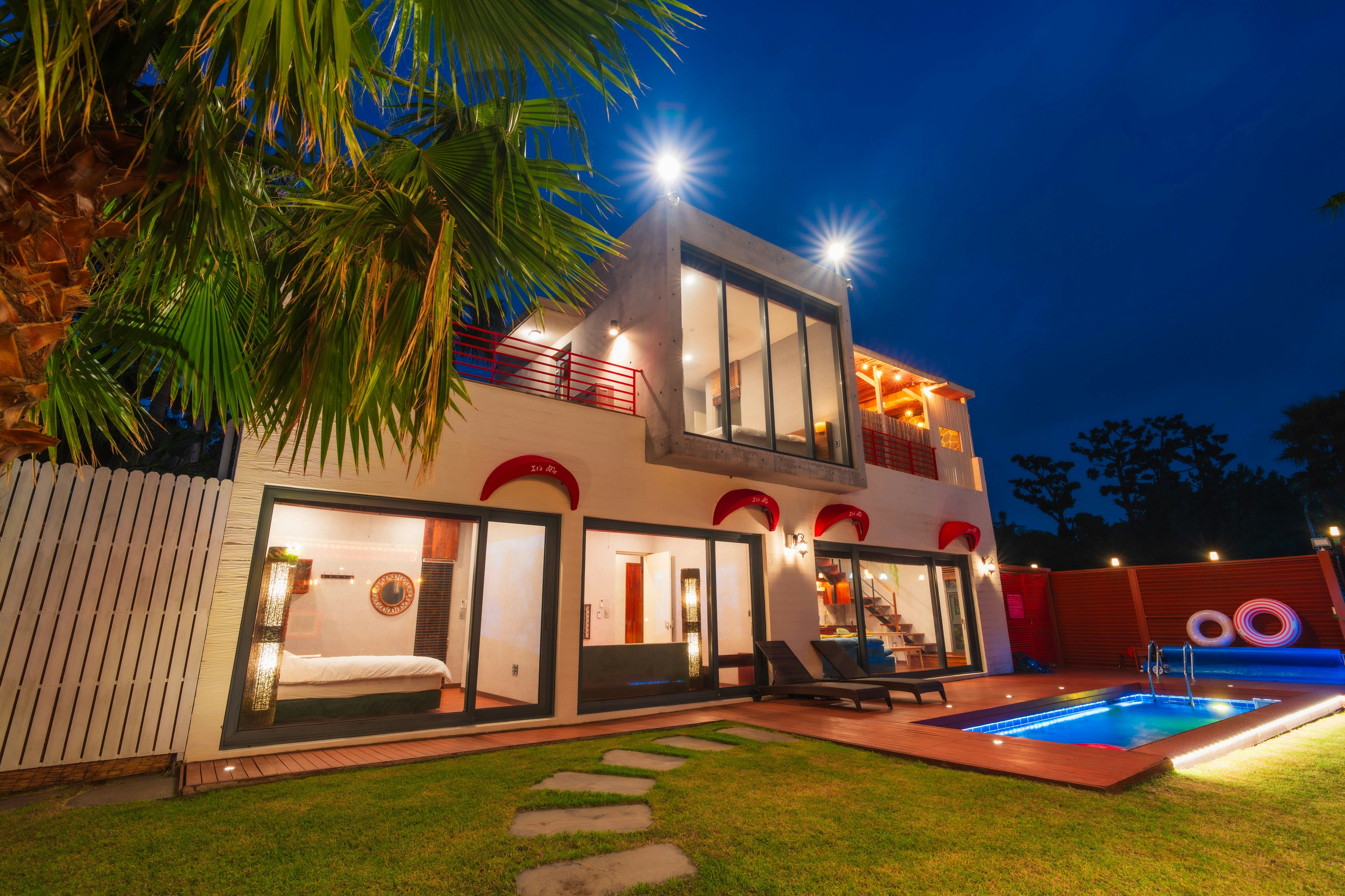 Modern home with a pool at night.