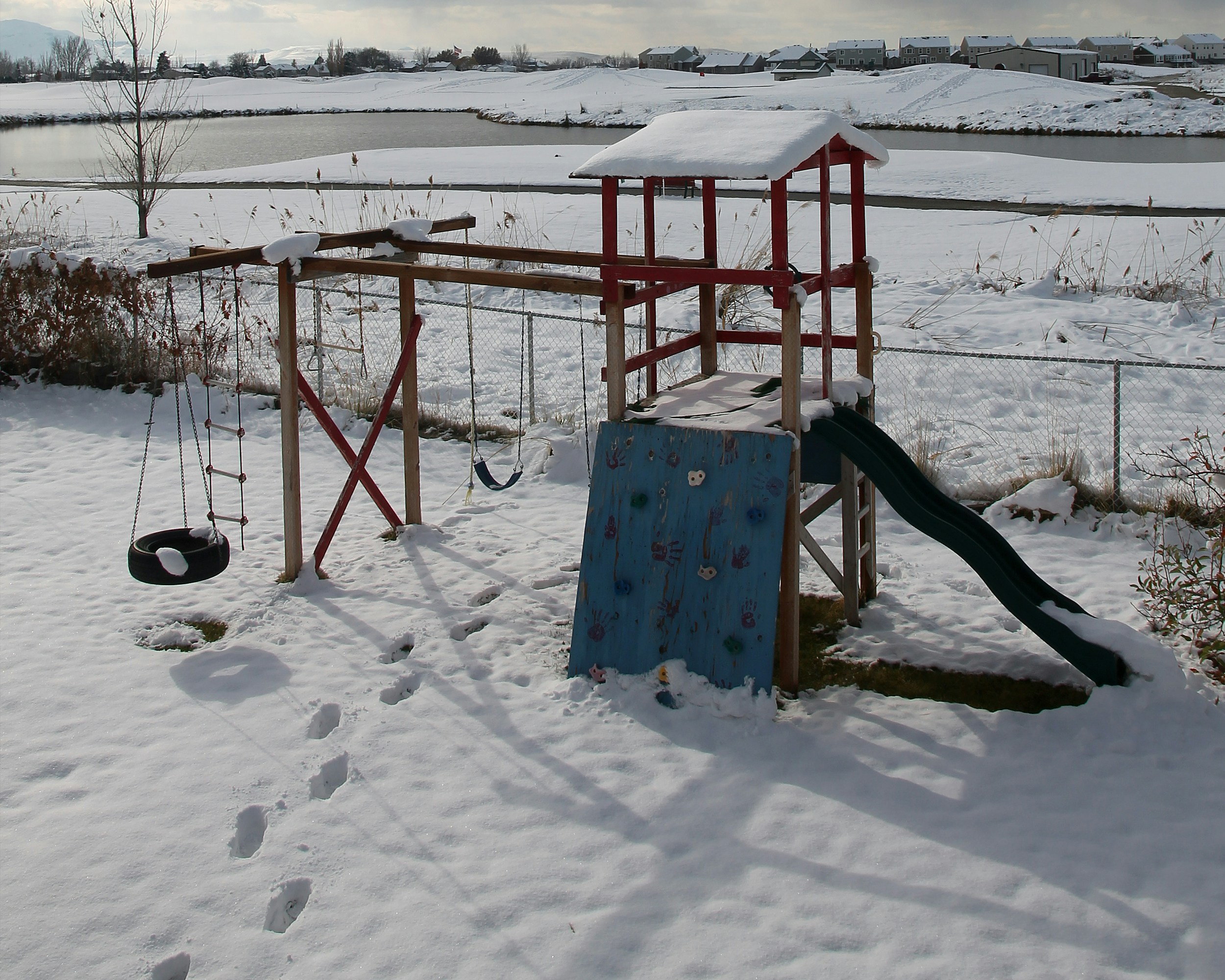 Snow covers a playground on a winter day.
