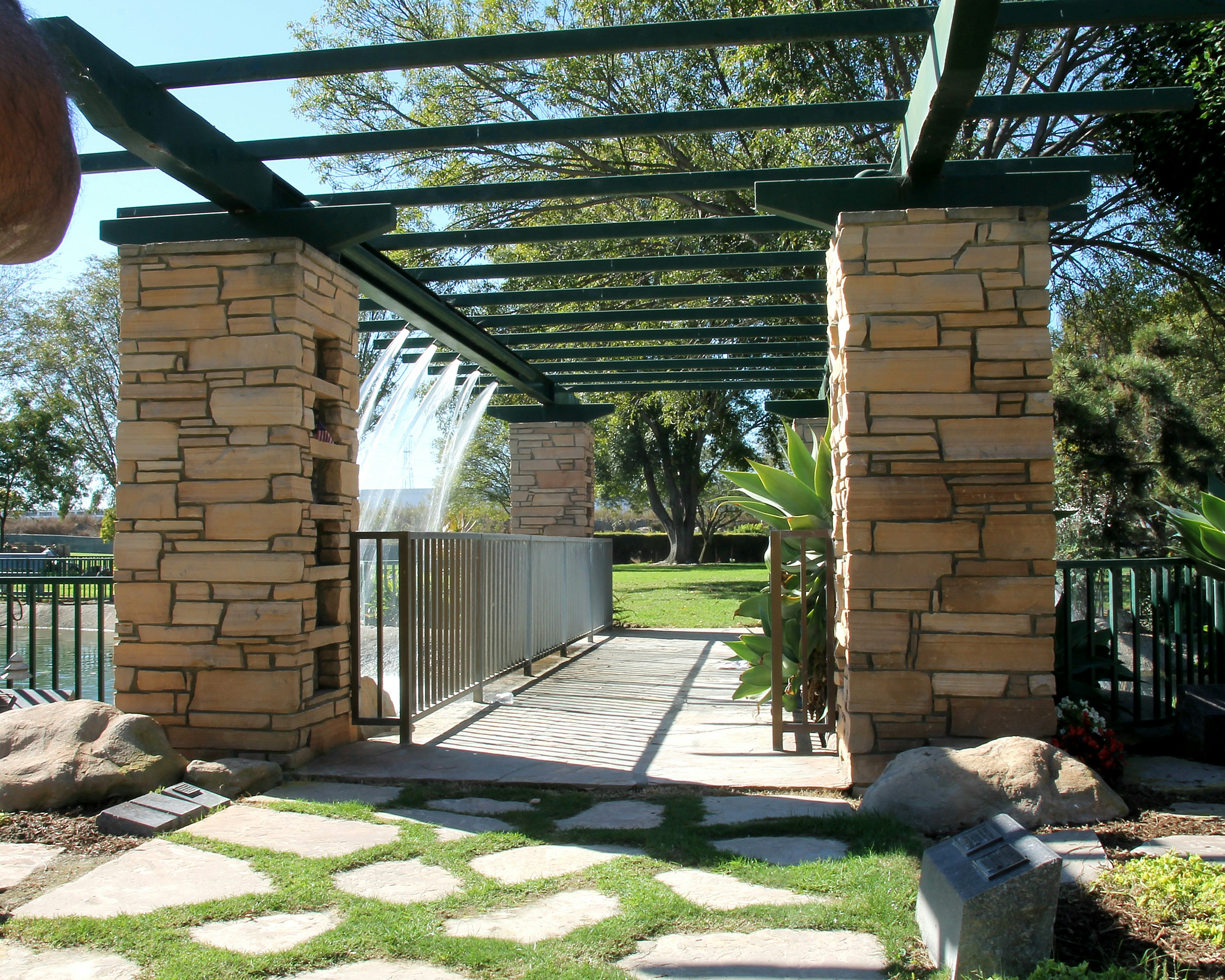 A stone archway frames a garden fountain.